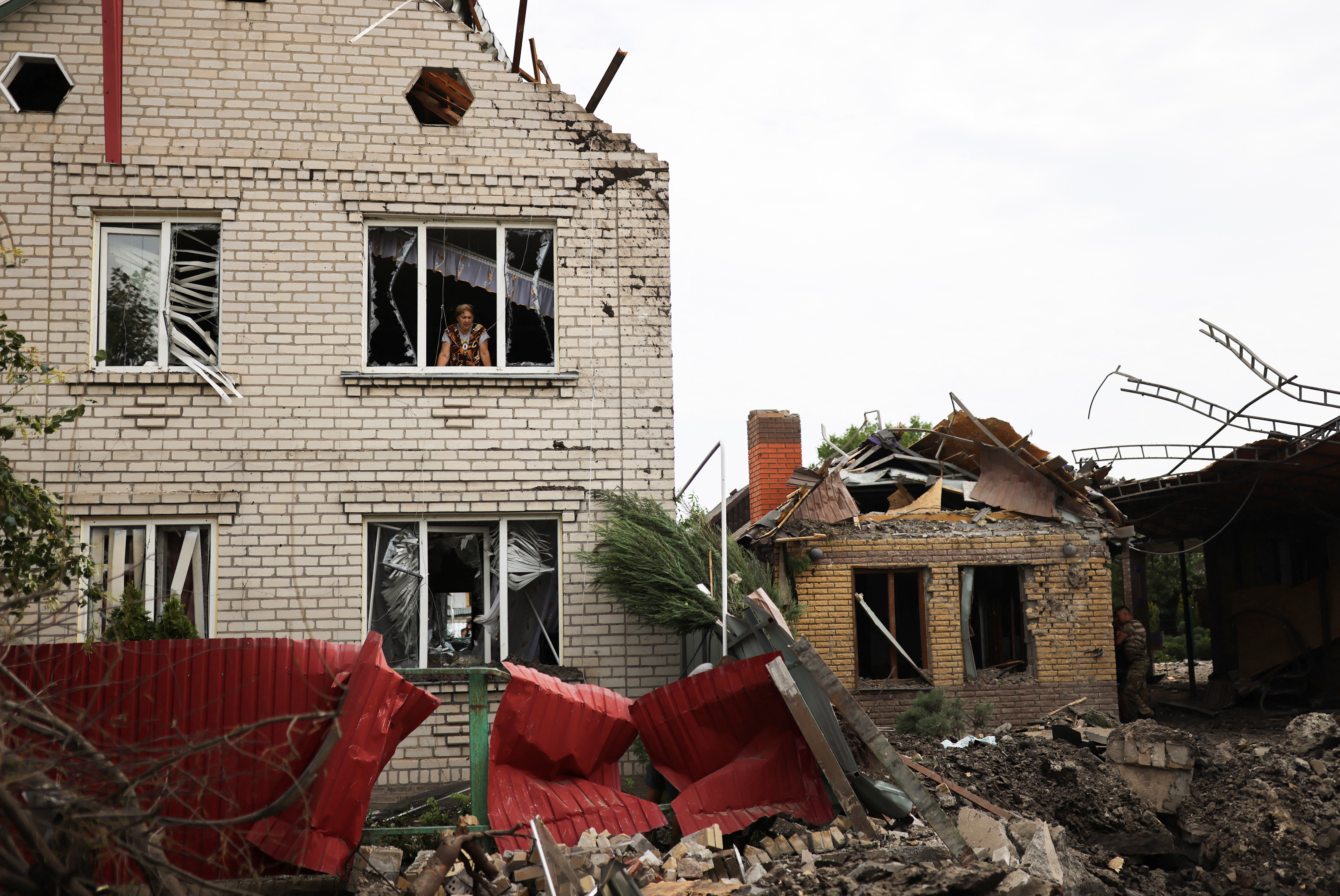 Iryna looks at destroyed houses, after military strikes in Kramatorsk