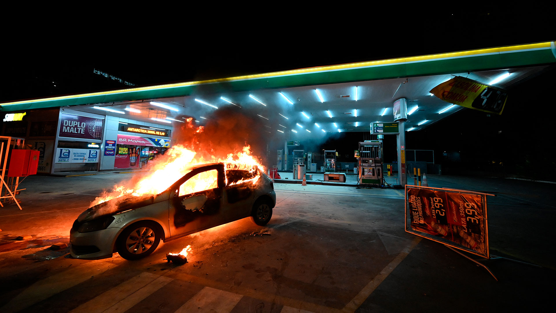 Un vehículo prendido fuego en una estación de servicio (EVARISTO SA / AFP)