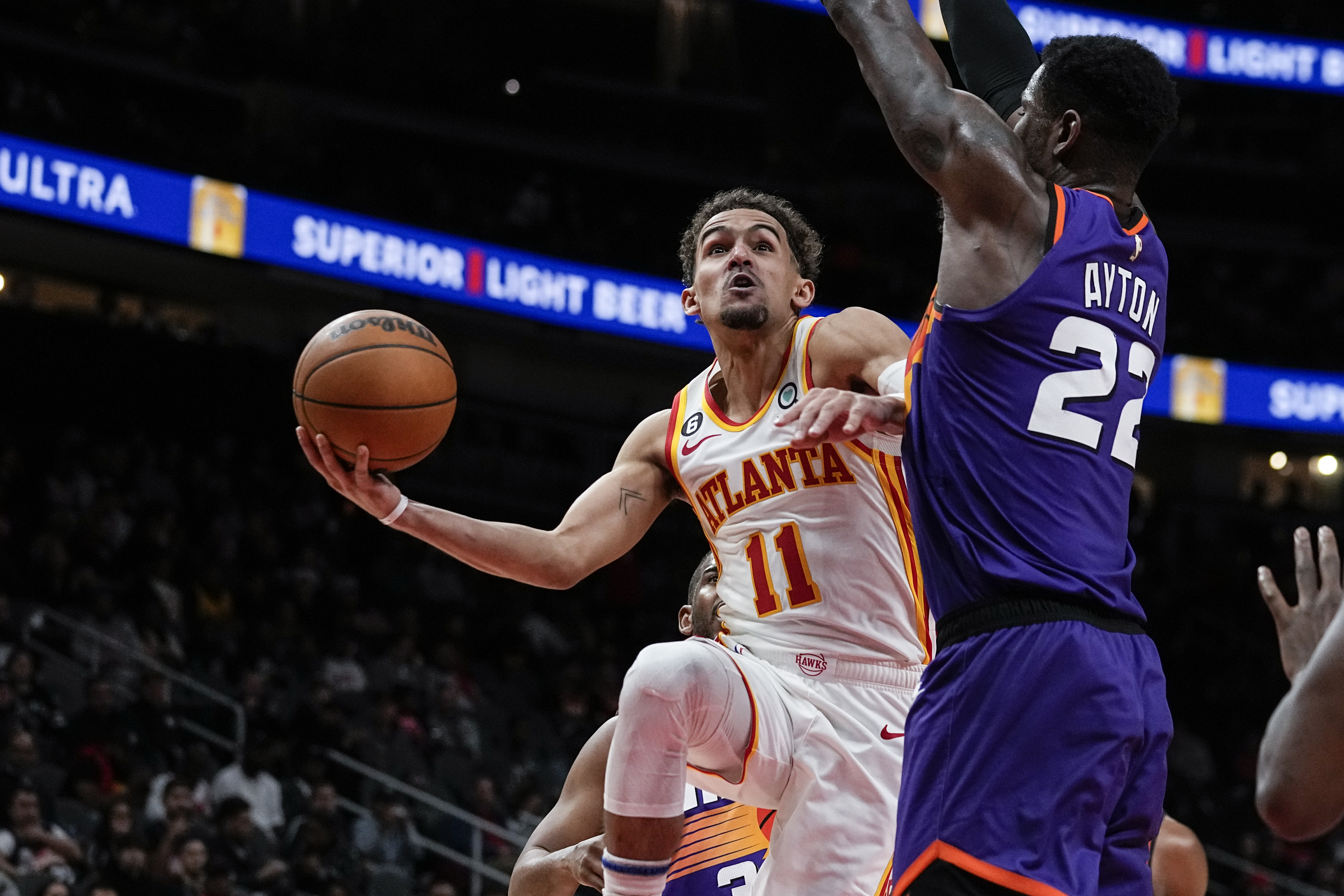 Atlanta Hawks guard Trae Young scores off Phoenix Suns' Deandre Ayton in a game on Thursday, Feb. 9, 2023 (AP Photo/John Bazemore)