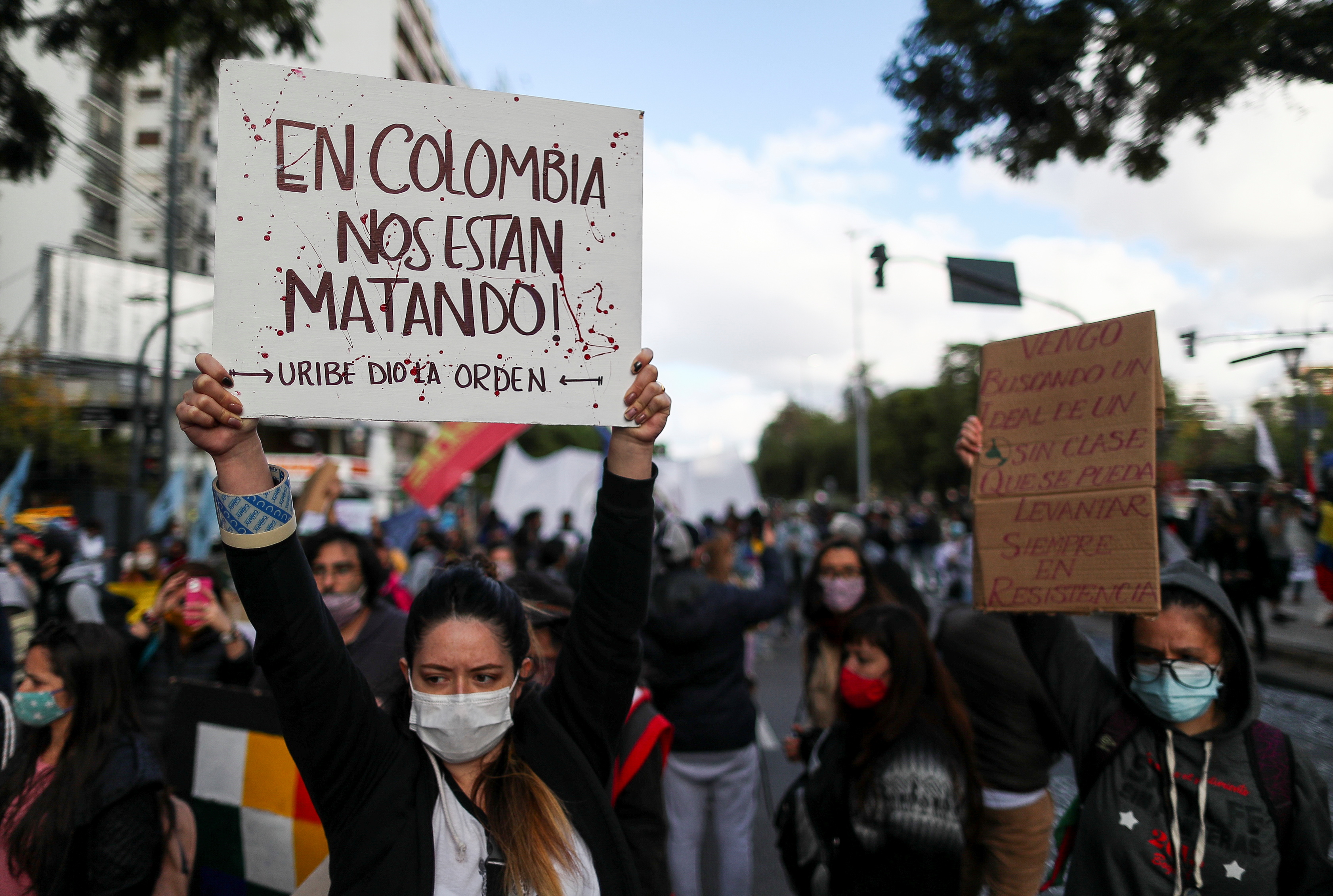 A demonstrator holds a placard that reads "In Colombia they are killing us", during a protest against what they say was police brutality exerted in recent protests in Colombia against President Ivan Duque's government's tax reform, outside the Colombian consulate in Buenos Aires, Argentina May 4, 2021. REUTERS/Agustin Marcarian