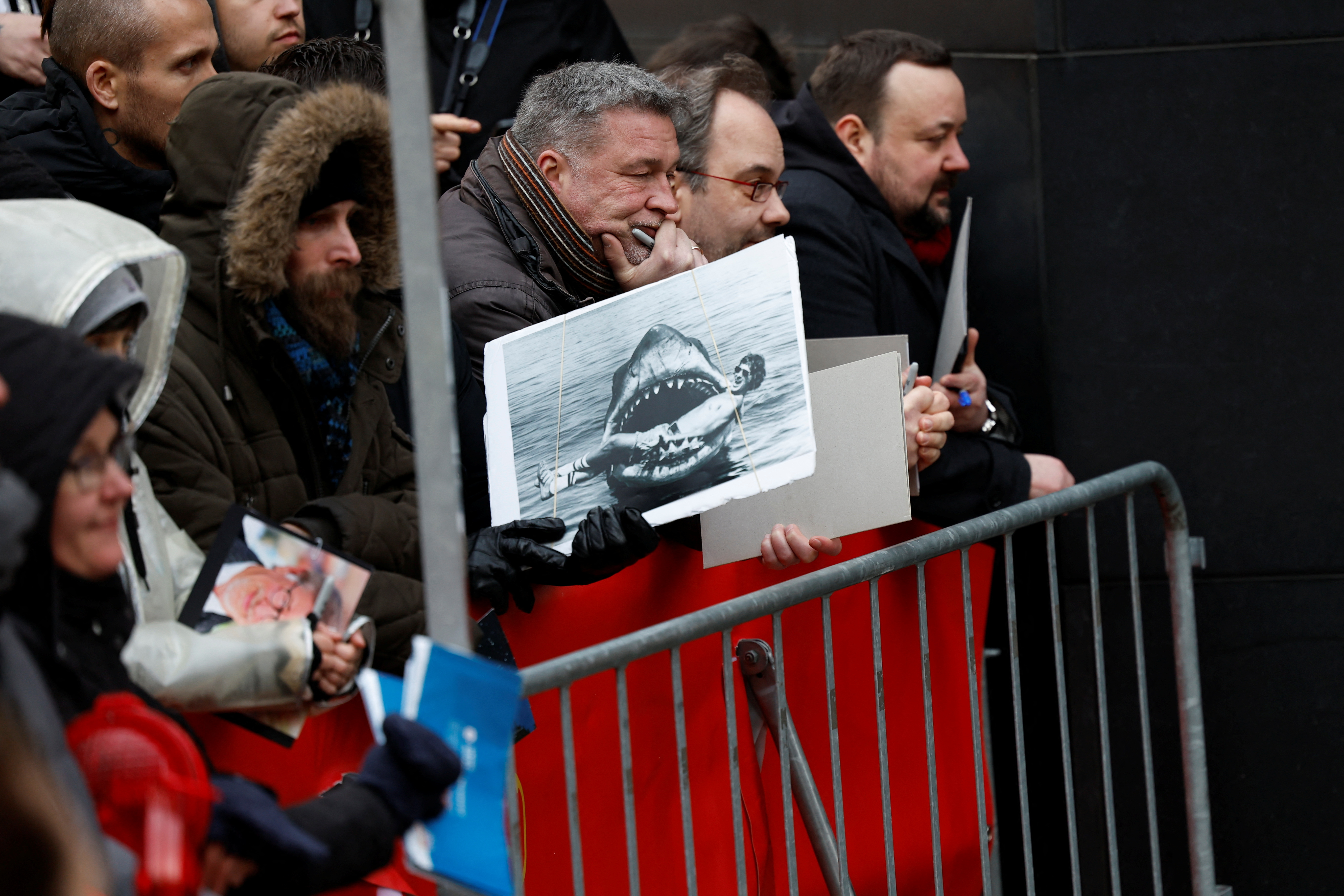 Una persona sostiene una foto de "Tiburón" atrapando a Spielberg antes de la llegada del director a la sesión de fotos (REUTERS/Michele Tantussi)
