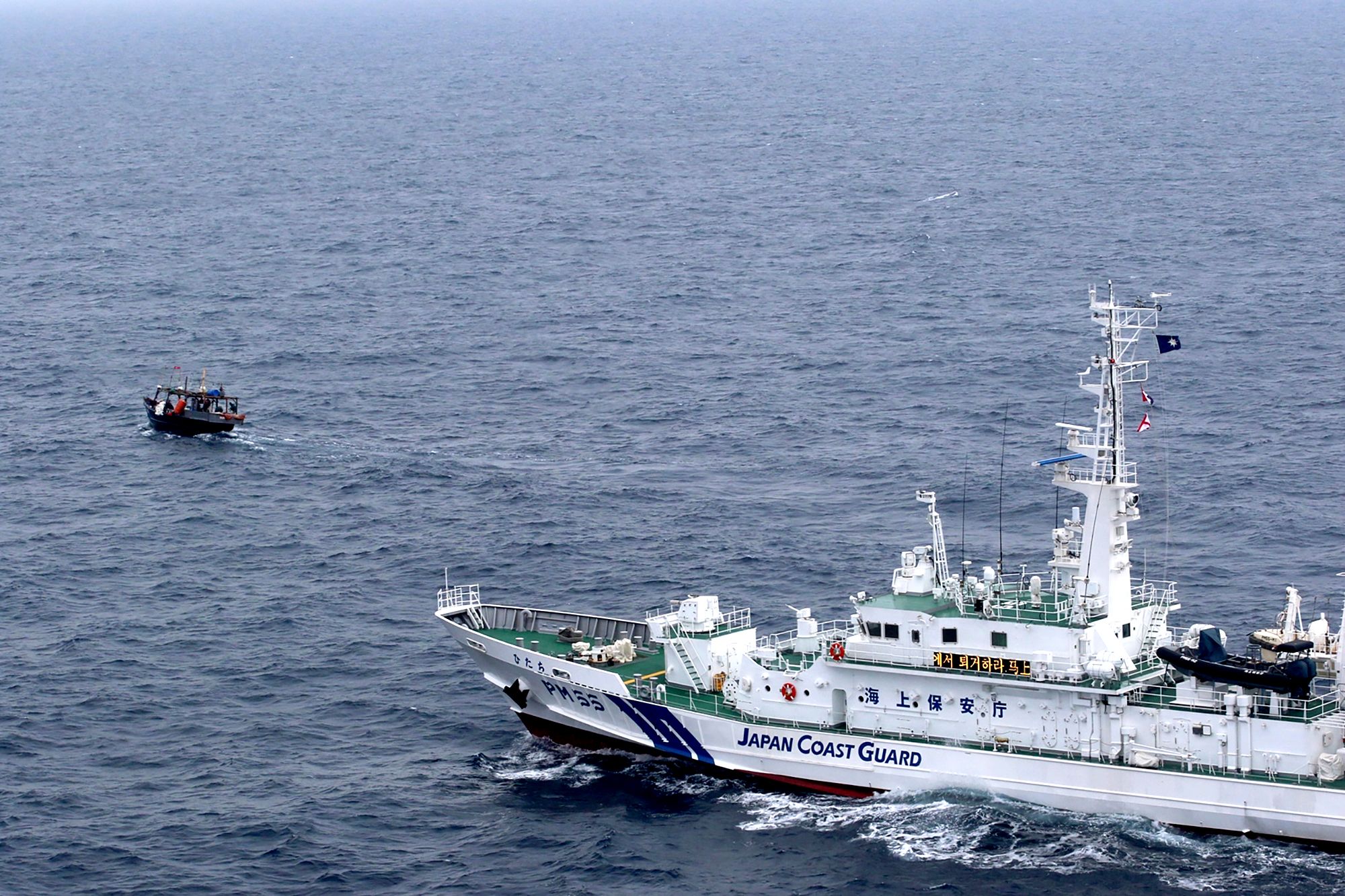 Una embarcación de patrulla de la Guardia Costera japonesa se acerca a un barco pesquero norcoreano para advertirles que abandonen las aguas cerca de Yamatotai, Japón, a fines de mayo de 2019. (Guardia Costera de Japón a través de AP/archivo)