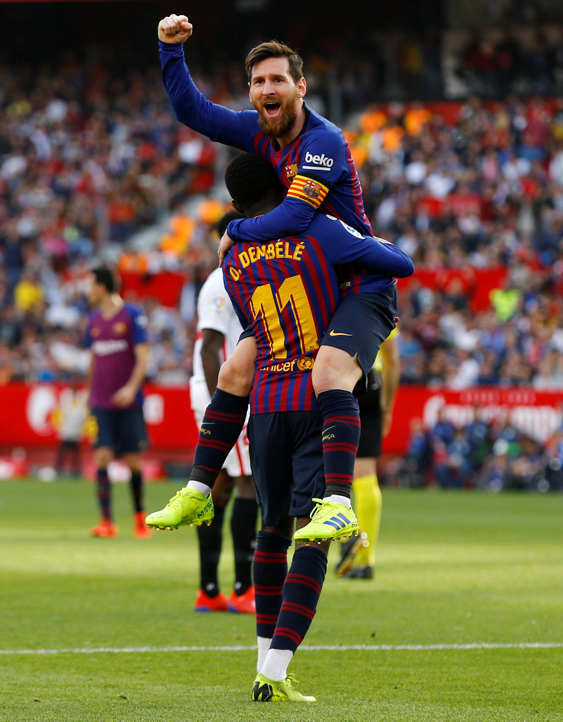 Ousmane Dembélé eleva en lo alto a Lionel Messi durante un partido del Barcelona ante Sevilla