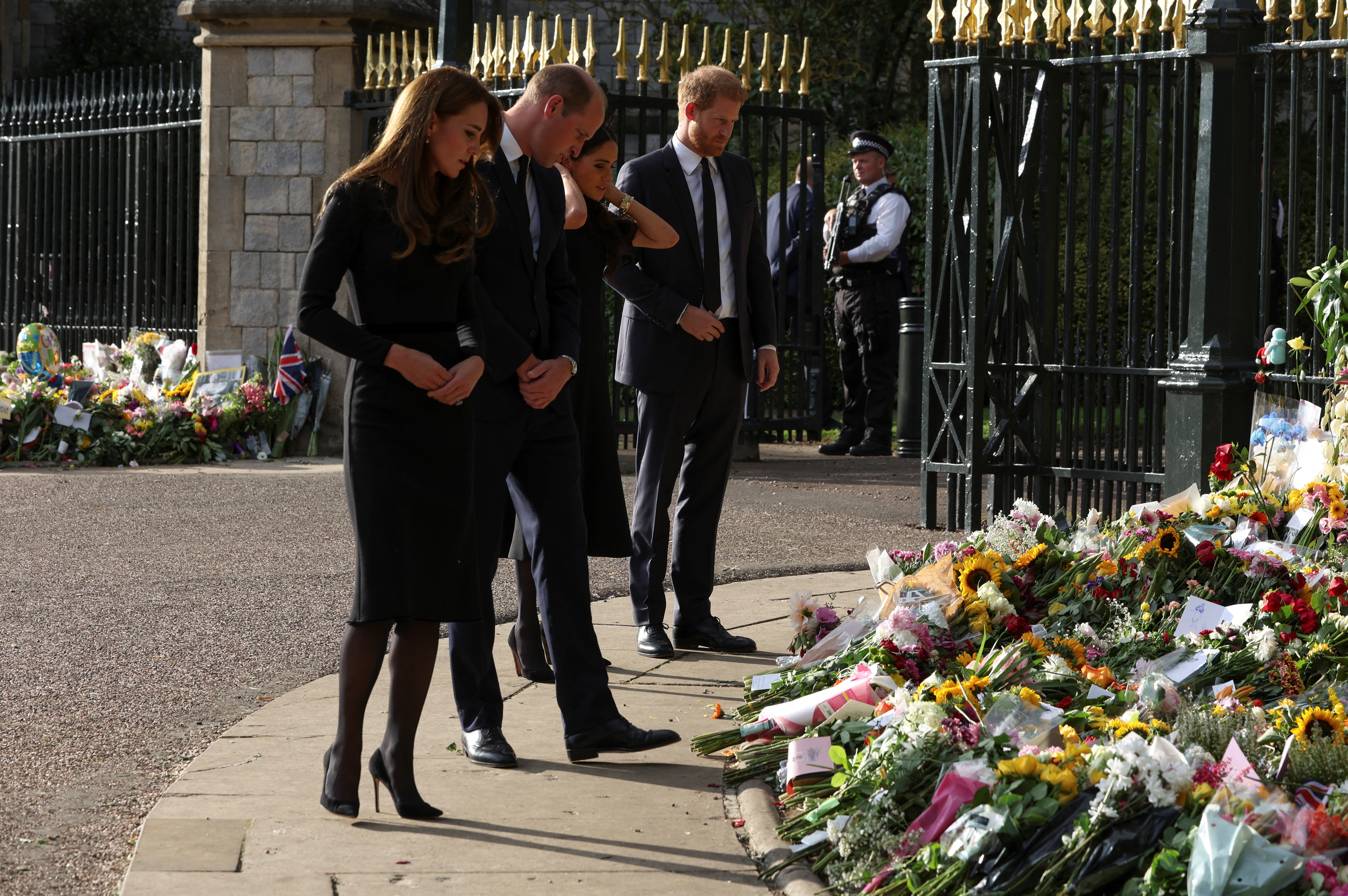 Los hijos del rey Carlos III y sus esposas miran las ofrendas florales que dejaron los seguidores de la reina Isabel II para rendirle homenaje este 10 de septiembre de 2022, a dos días de su muerte