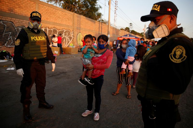 Personas fuera de una base de la Fuerza Aérea peruana espernado por vuelos que los lleven de regreso al la amazonía local en medio de la propagación del coronavirus, en Lima, Perú, el 24 de abril (REUTERS/Sebastián Castañeda)