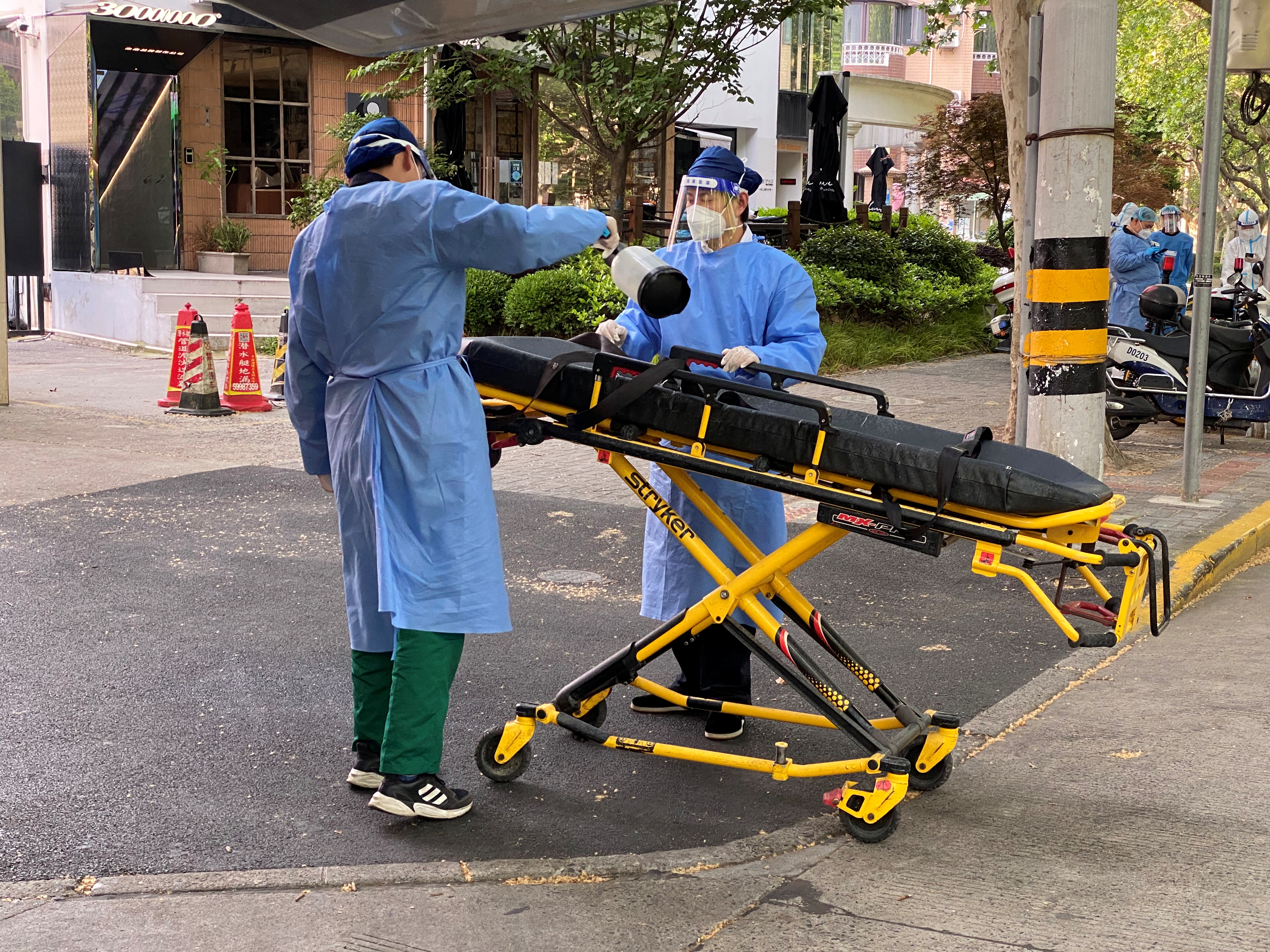Un trabajador con traje de protección rocía desinfectante sobre una camilla, tras el brote de la enfermedad por coronavirus (COVID-19) en Shanghái, China el 21 de abril de 2022. REUTERS/Andrew Galbraith