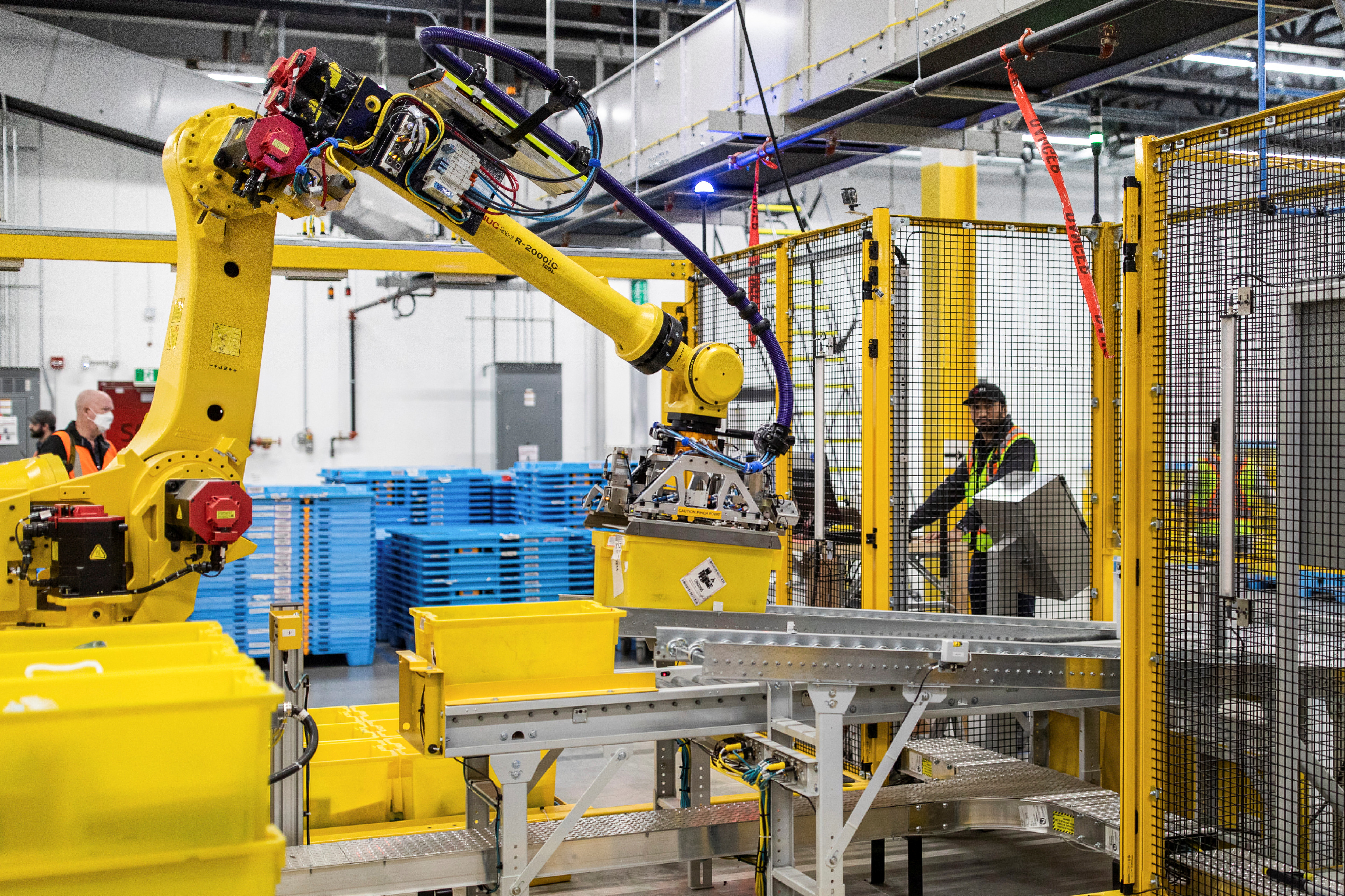 Los paquetes de Amazon son clasificados por un brazo robótico durante una visita al centro de cumplimiento de instalaciones robóticas avanzadas, YHM1, en Hamilton, Ontario, Canadá 19 de abril de 2022.  REUTERS/Nick Iwanyshyn