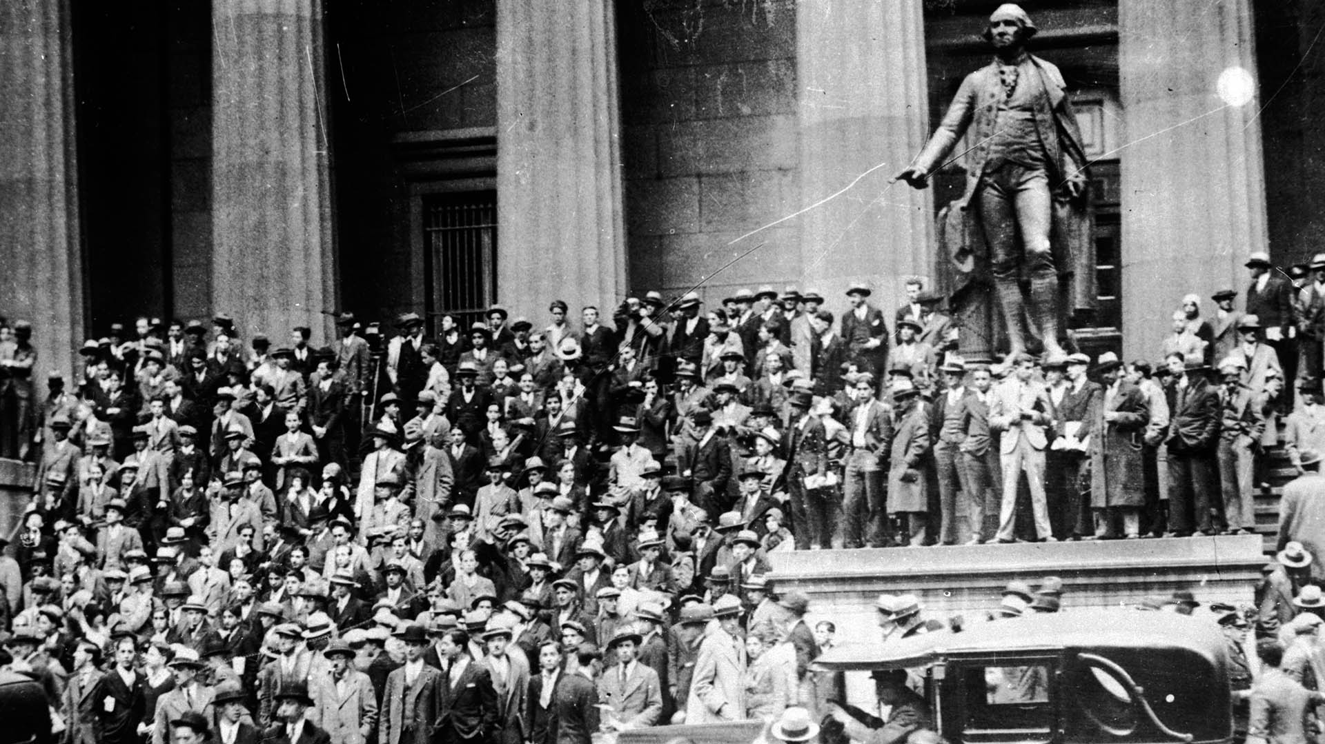 Una multitud fuera del edificio del Tesoro Nacional (hoy la Federal Hall National Memorial) junto a la estatua de George Washington, frente a la Bolsa de Nueva York, en octubre de 1929 (Photo by Keystone/Getty Images)