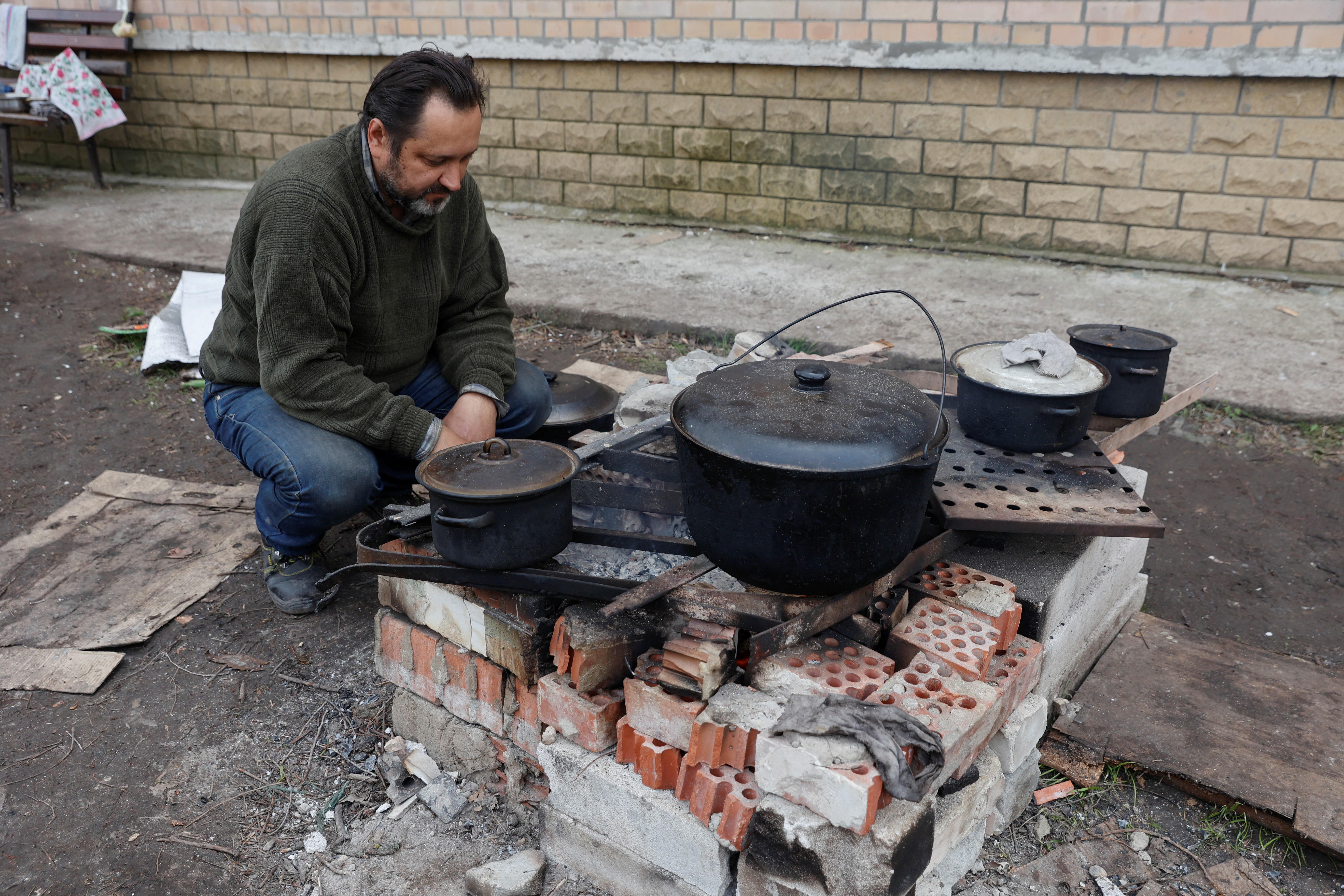 Un residente local prepara comida en una calle, mientras continúa el ataque de Rusia a Ucrania, en Sievierodonetsk. REUTERS/Serhii Nuzhnenko