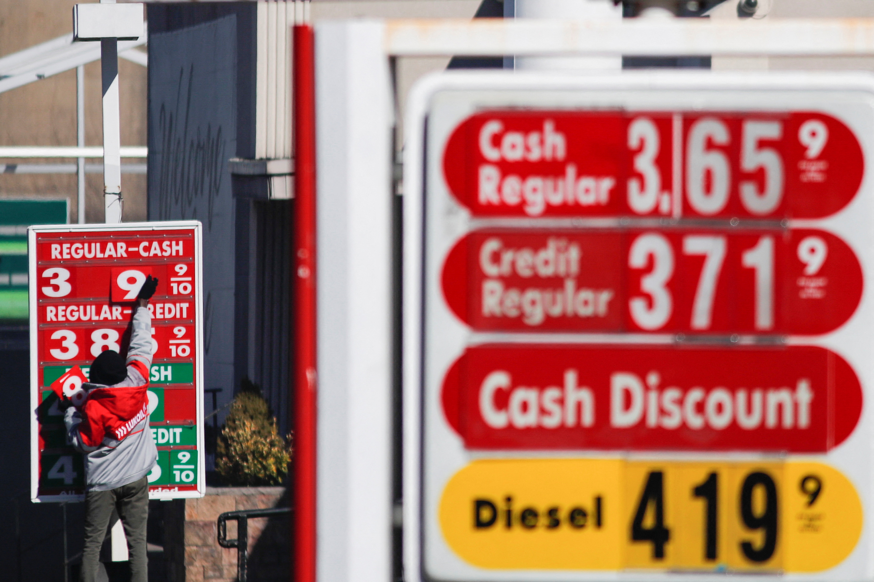 Un trabajador cambia los números de un precio en la gasolinera Lukoil, después de que los funcionarios locales votaran para suspender la licencia comercial de las gasolineras locales de Lukoil tras la invasión rusa de Ucrania, en Newark, Nueva Jersey. REUTERS/Eduardo Munoz