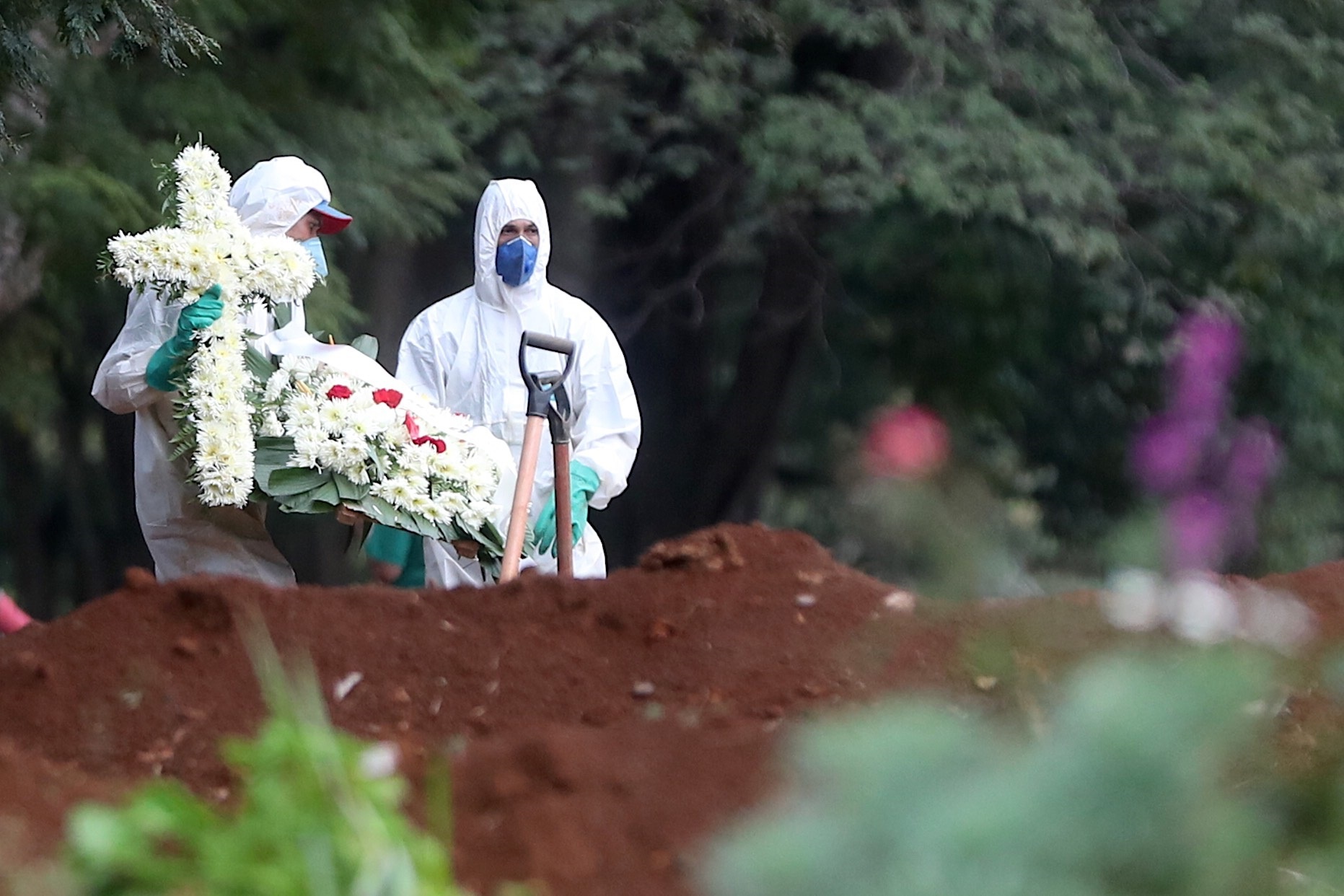 Empleados del servicio funerario entierran a una víctima de COVID-19 en el cementerio de Vila Formosa, situado en Sao Paulo, Brasil (EFE/Fernando Bizerra)
