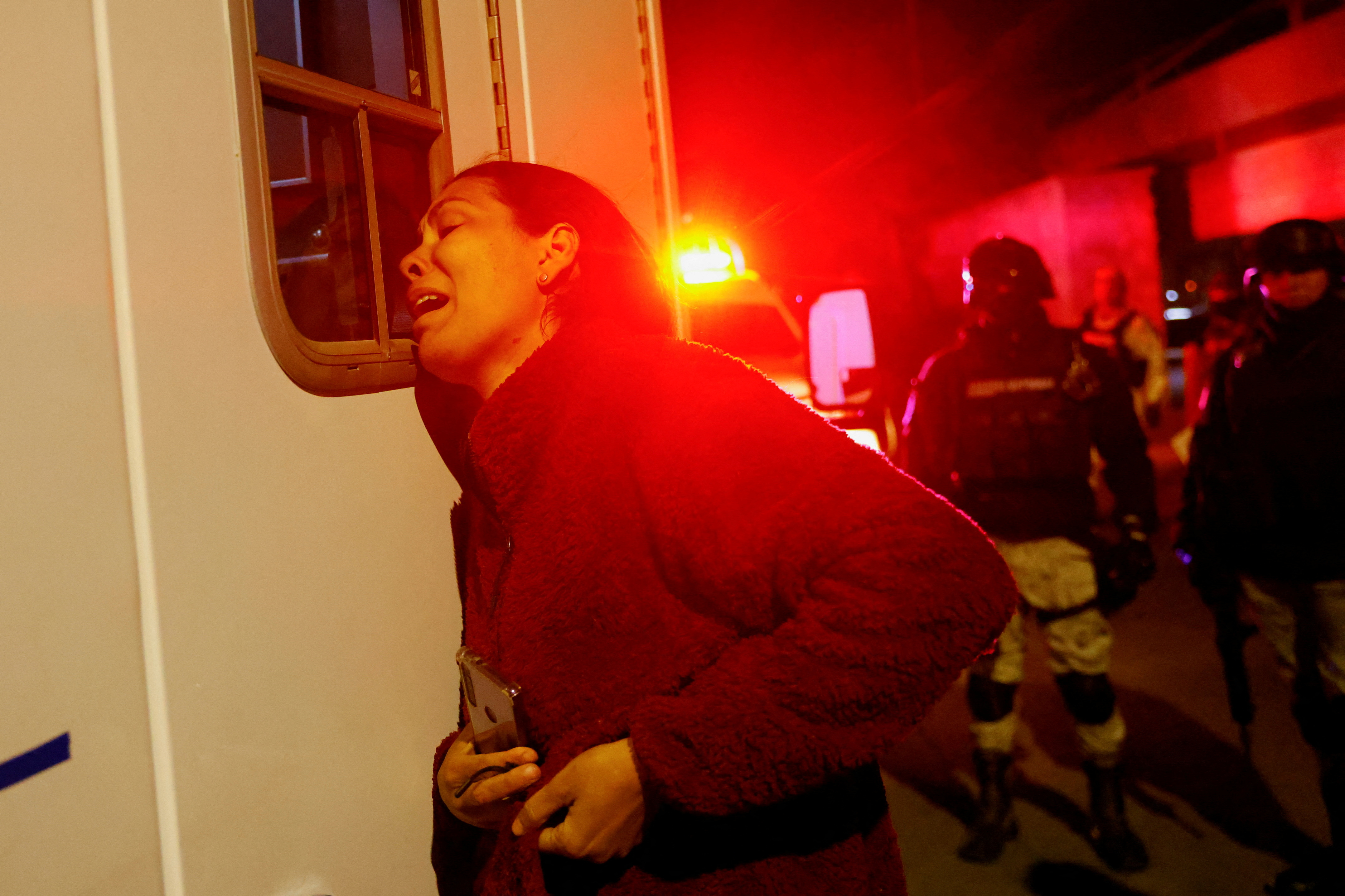 Migrante venezolana espera a las afueras de una ambulancia por su esposo que resultó herido tras el incendio. (REUTERS/Jose Luis Gonzalez)