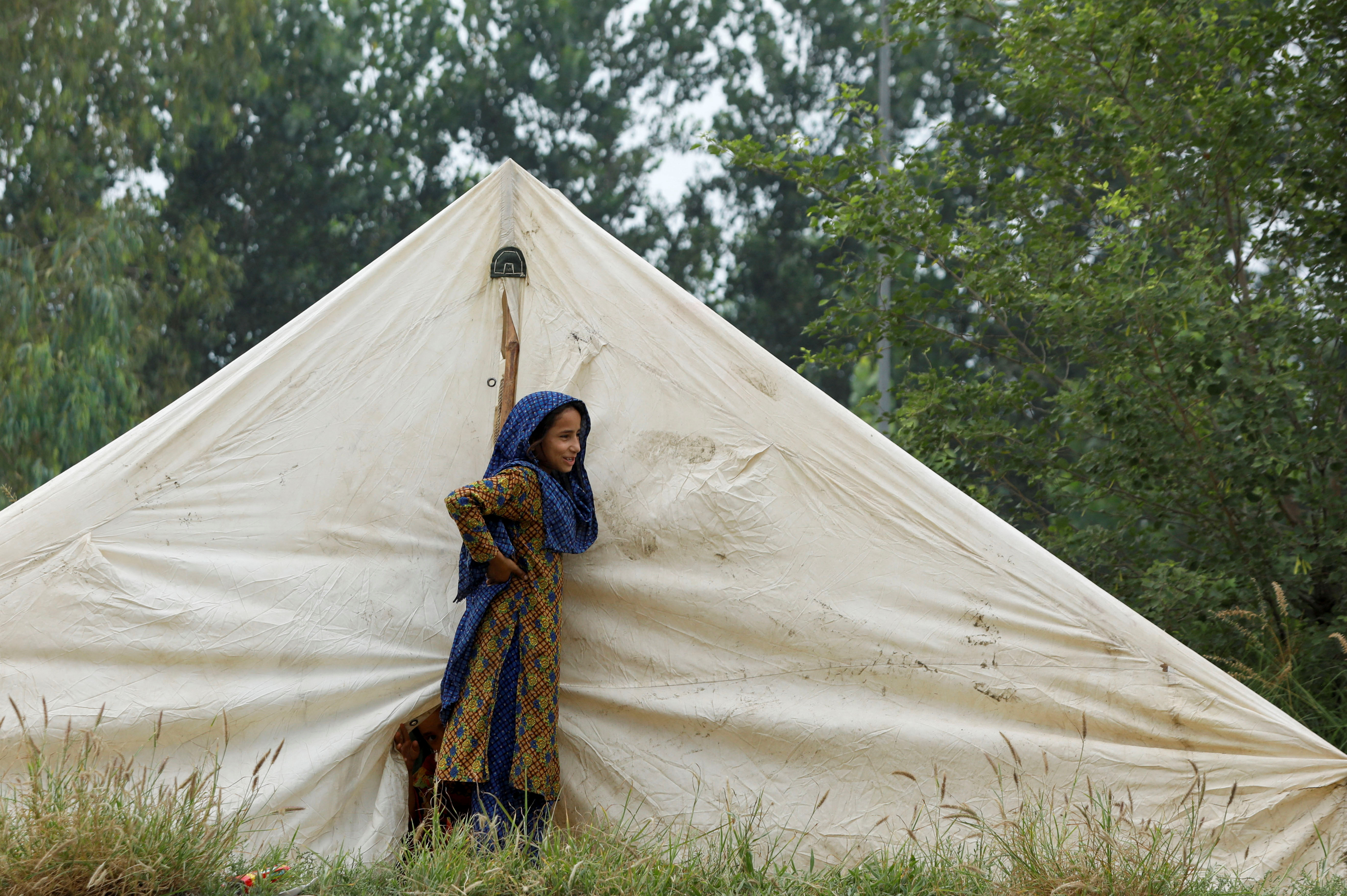 Una niña parada junto a su carpa, donde se refugia tras las inundaciones en Charsadda, Pakistán (REUTERS/Fayaz Aziz)