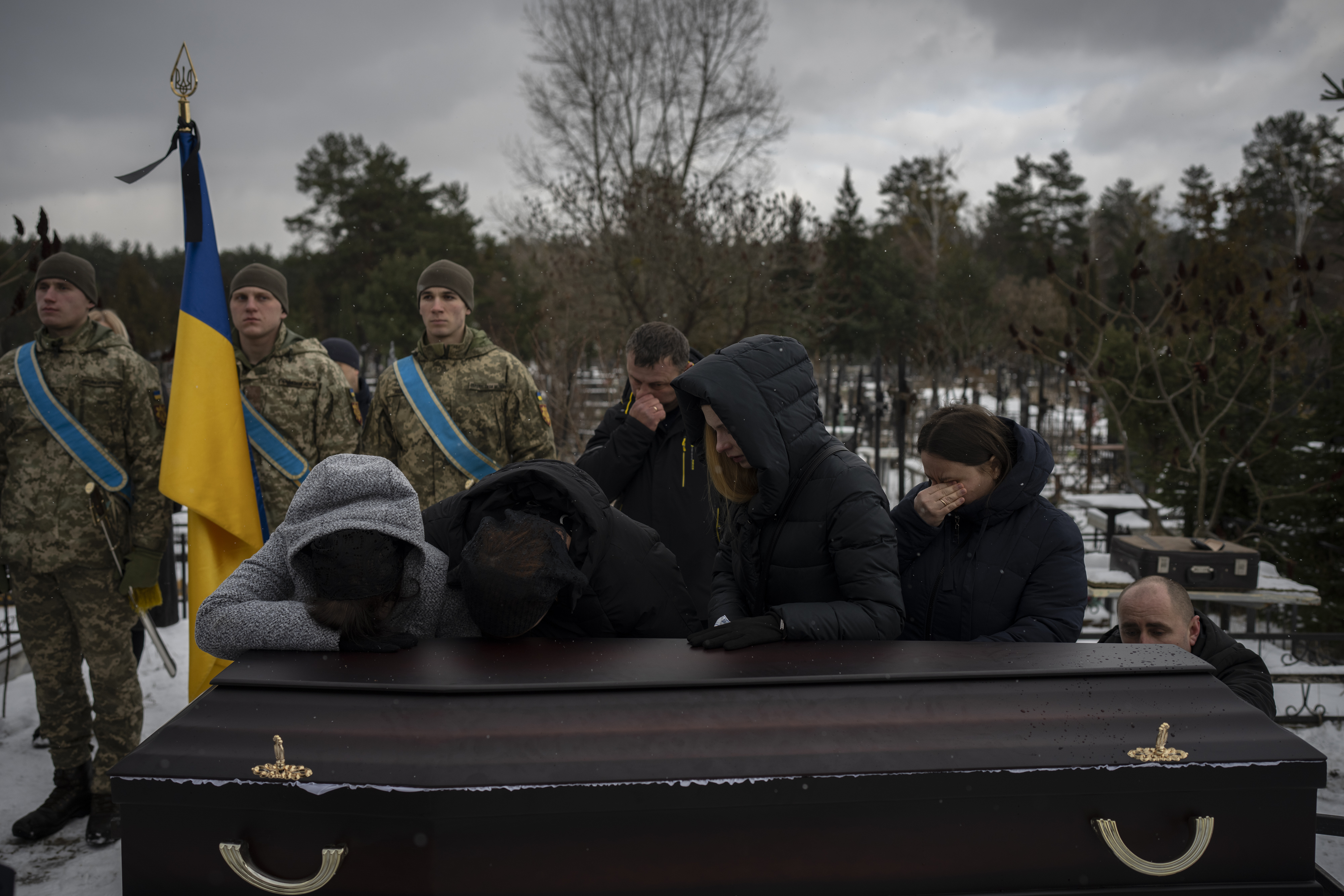 Familiares, lloran junto al féretro de Eduard Strauss, un soldado ucraniano que murió en un combate en Bajmut el 17 de enero, durante su funeral, en Irpin, Ucrania, el 6 de febrero de 2023. (AP Foto/Daniel Cole)