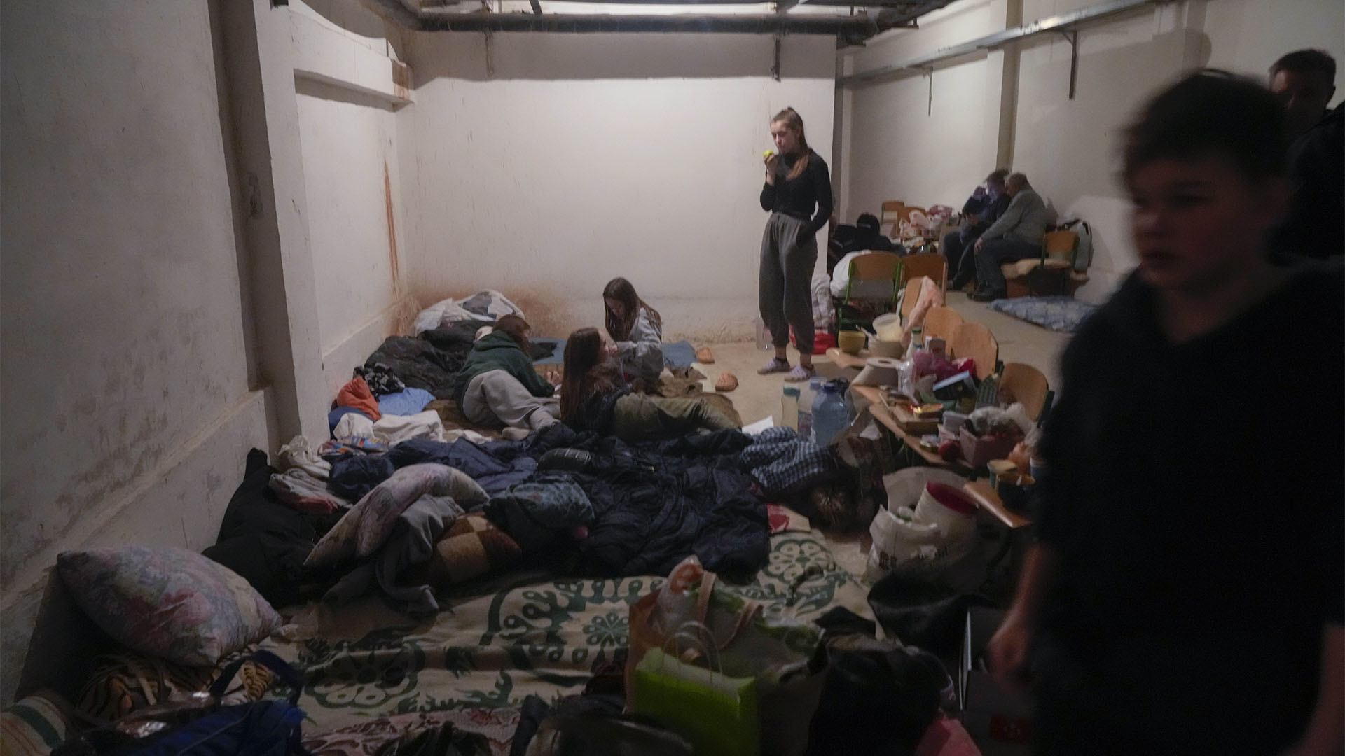 ARCHIVO - Personas se refugian del bombardeo de la artillería rusa en el sótano de una escuela en el pueblo de Horenka cerca de Kiev, Ucrania, el domingo 6 de marzo de 2022. (Foto AP/Efrem Lukatsky, Archivo)
