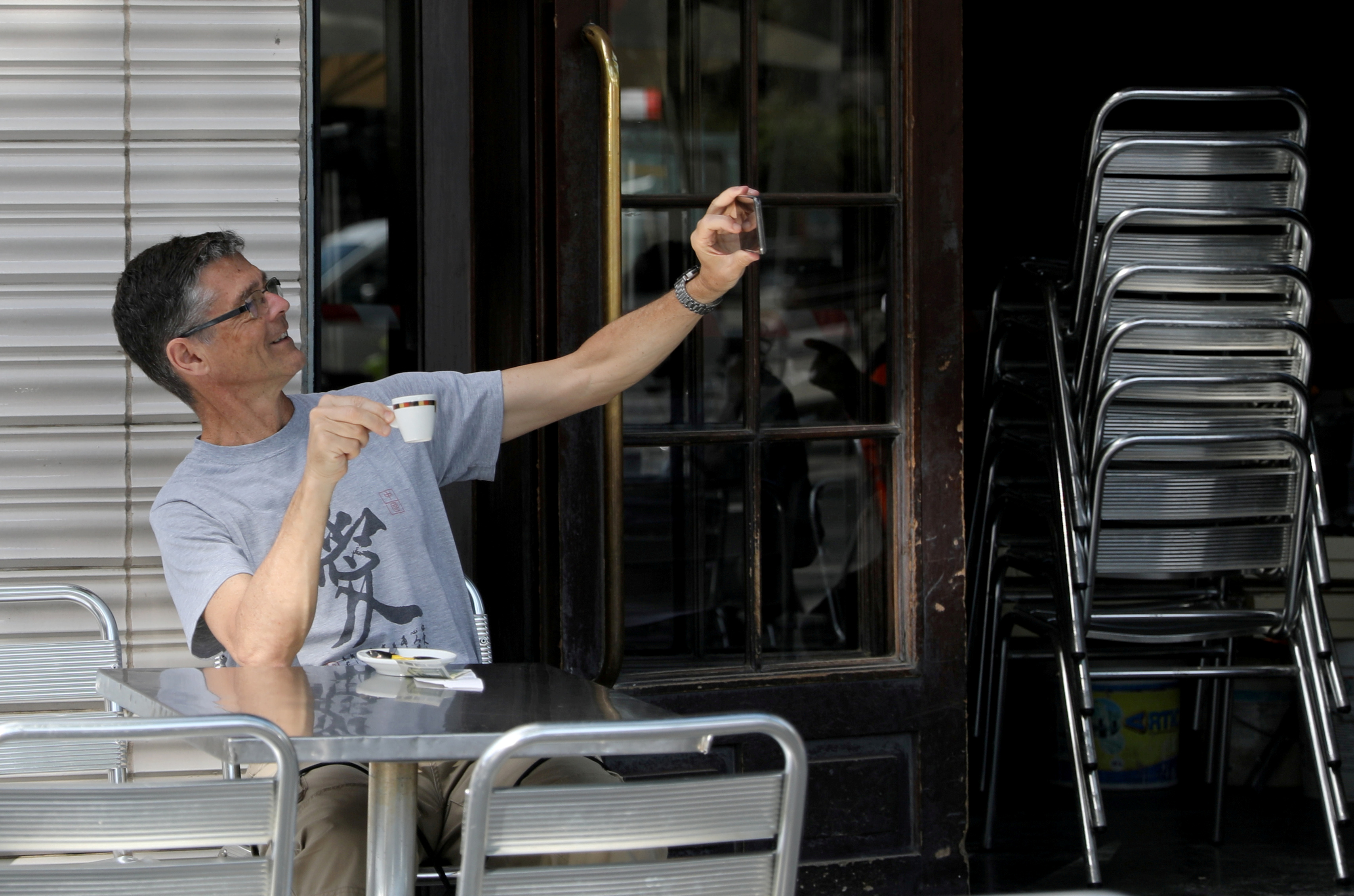 Un hombre se toma una selfie mientras toma un café en el bar Zurich de Plaza Catalunya en Barceolona (REUTERS/Nacho Doce)