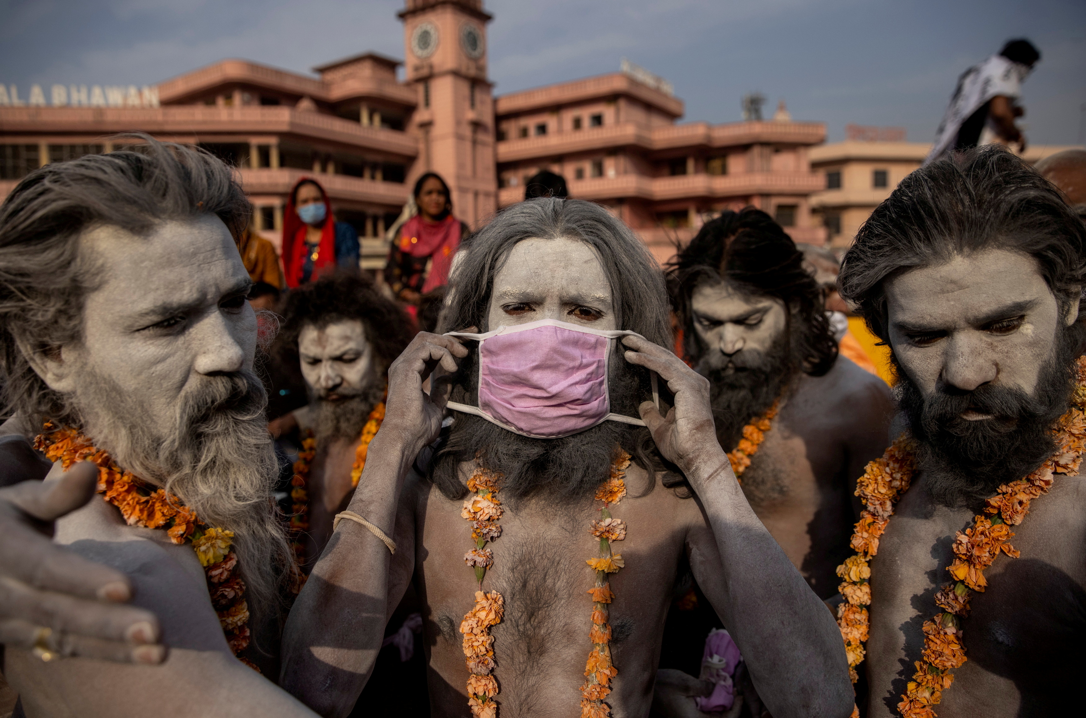 Un Naga Sadhu, u hombre santo hindú lleva una máscara antes de la procesión para darse un baño en el río Ganges durante el Shahi Snan en el "Kumbh Mela", o Festival de la Jarra, en medio de la propagación de la enfermedad del coronavirus (COVID-19), en Haridwar, India, el 12 de abril de 2021.