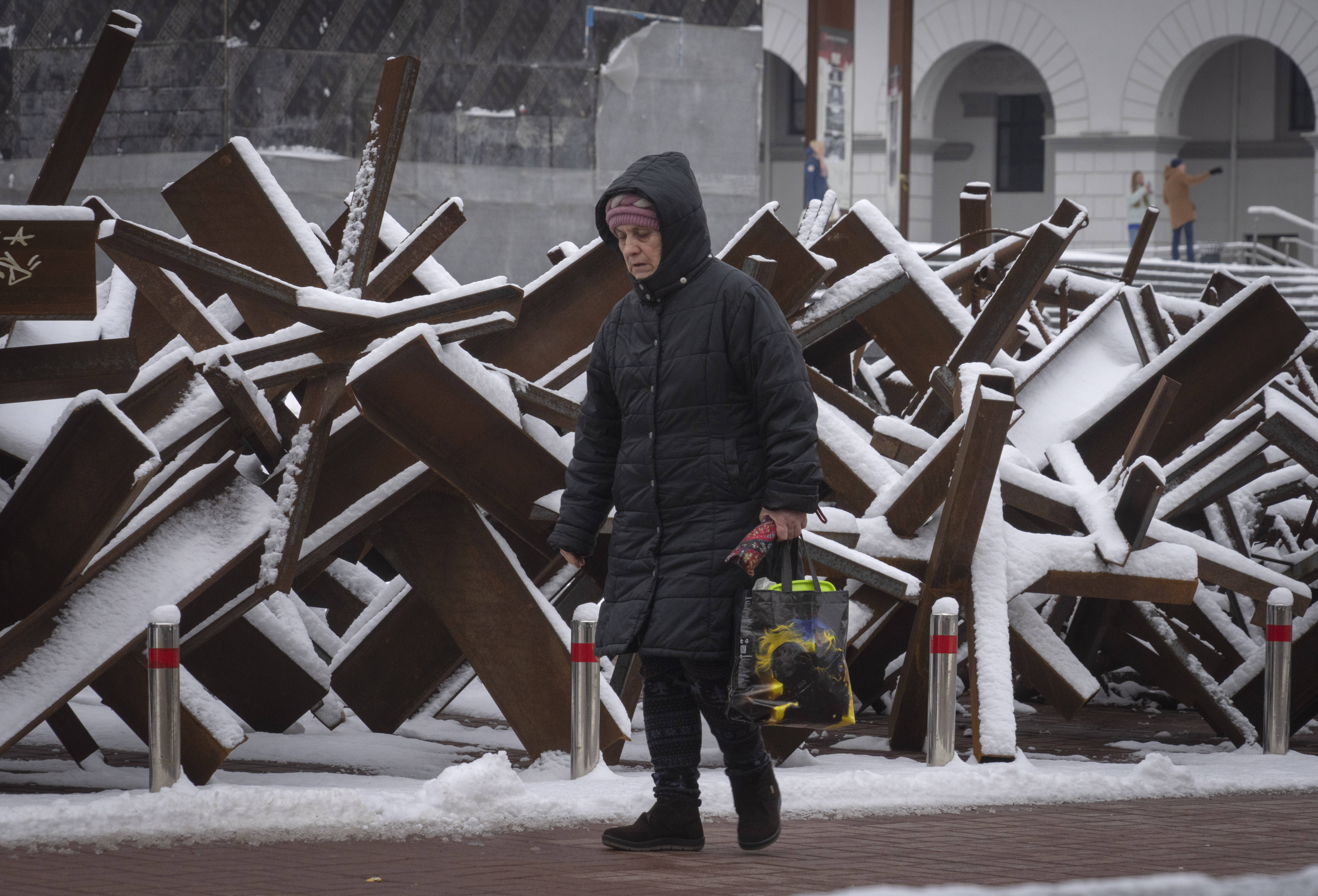 Una mujer camina frente a una barricada antitanques en Kiev, Ucrania