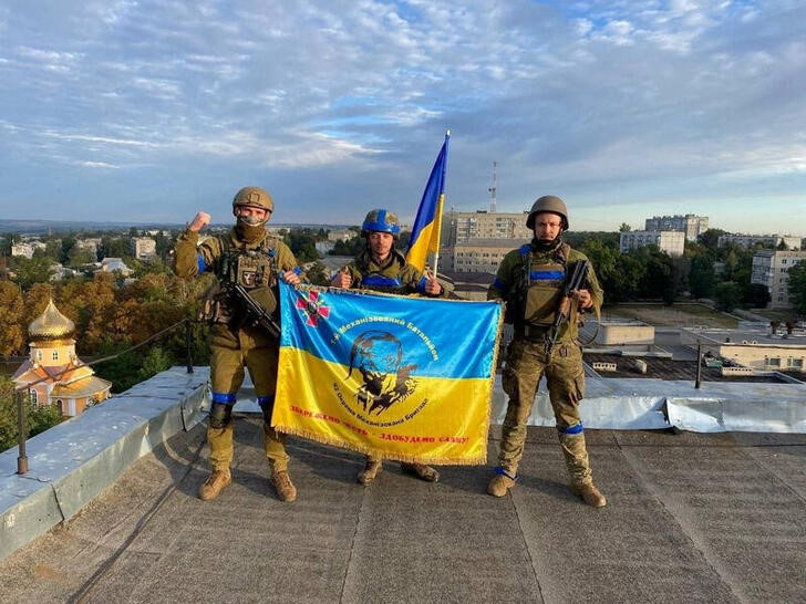 Soldados ucranianos muestran una bandera de su país en una azotea en Kupiansk, Ucrania. 10 septiembre 2022. Telegram @kuptg/vía Reuters. ESTA IMAGEN FUE ENTREGADA POR UNA TERCERA PARTE. CRÉDITO OBLIGATORIO. NI VENTAS NI ARCHIVOS.