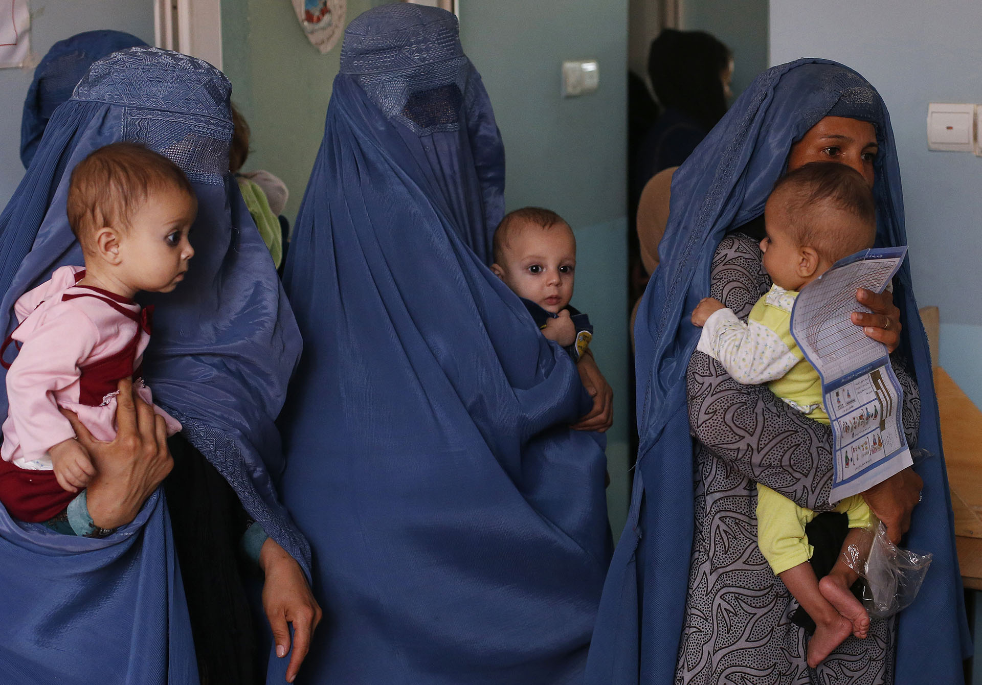 Tres madres sostienen a sus bebés que sufren de desnutrición mientras esperan en una clínica de UNICEF en Jabal Saraj, al norte de Kabul, Afganistán (AP Photo/Rafiq Maqbool)