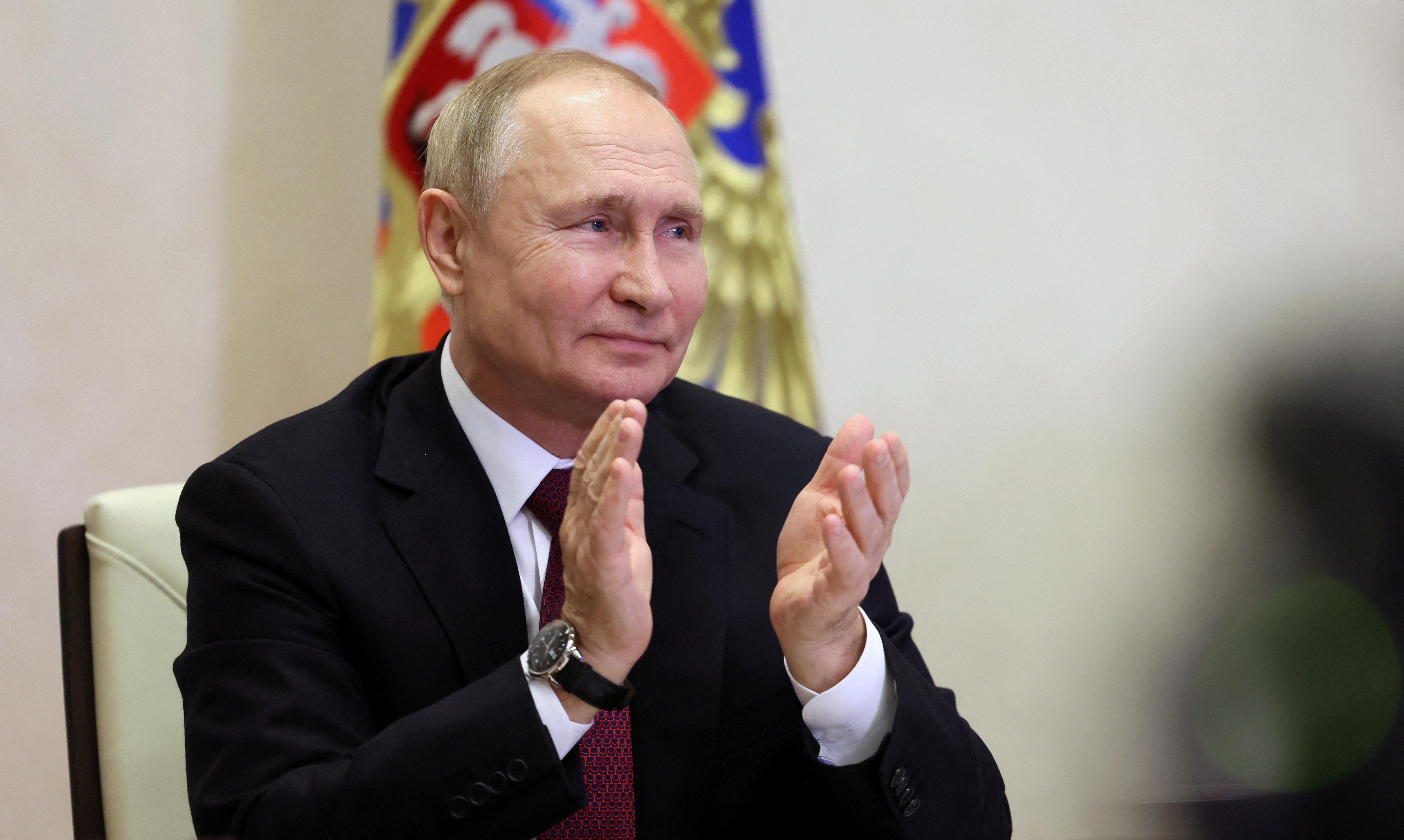 Vladimir Putin aplaude desde su residencia de Novo-Ogaryovo, durante la ceremonia que siguió por televisión de la botadura del rompehielos nuclear Yakutia, esta semana. (Sputnik/Aleksey Babushkin/Kremlin via REUTERS) 