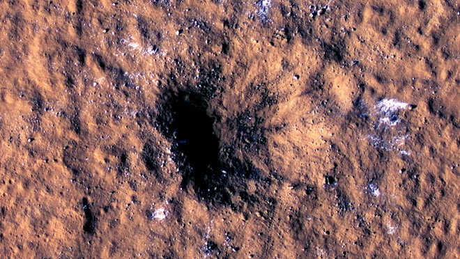 La cámara HiRISE ya obtuvo algunas imágenes muy particulares del martes, como estos bloques de agua presuntamente congelada alrededor del impacto de una roca en la región llamada llanura amazónica (NASA/JPL-Caltech/University of Arizona/Handout vía REUTERS)