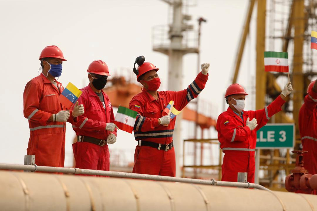 Trabajadores de la petrolera estatal Pdvsa con banderas iraníes y venezolanas saludan durante la llegada del buque tanque iraní "Fortune" a la refinería El Palito en Puerto Cabello, Venezuela, el 25 de mayo de 2020. (Palacio de Miraflores/Folleto vía REUTERS)