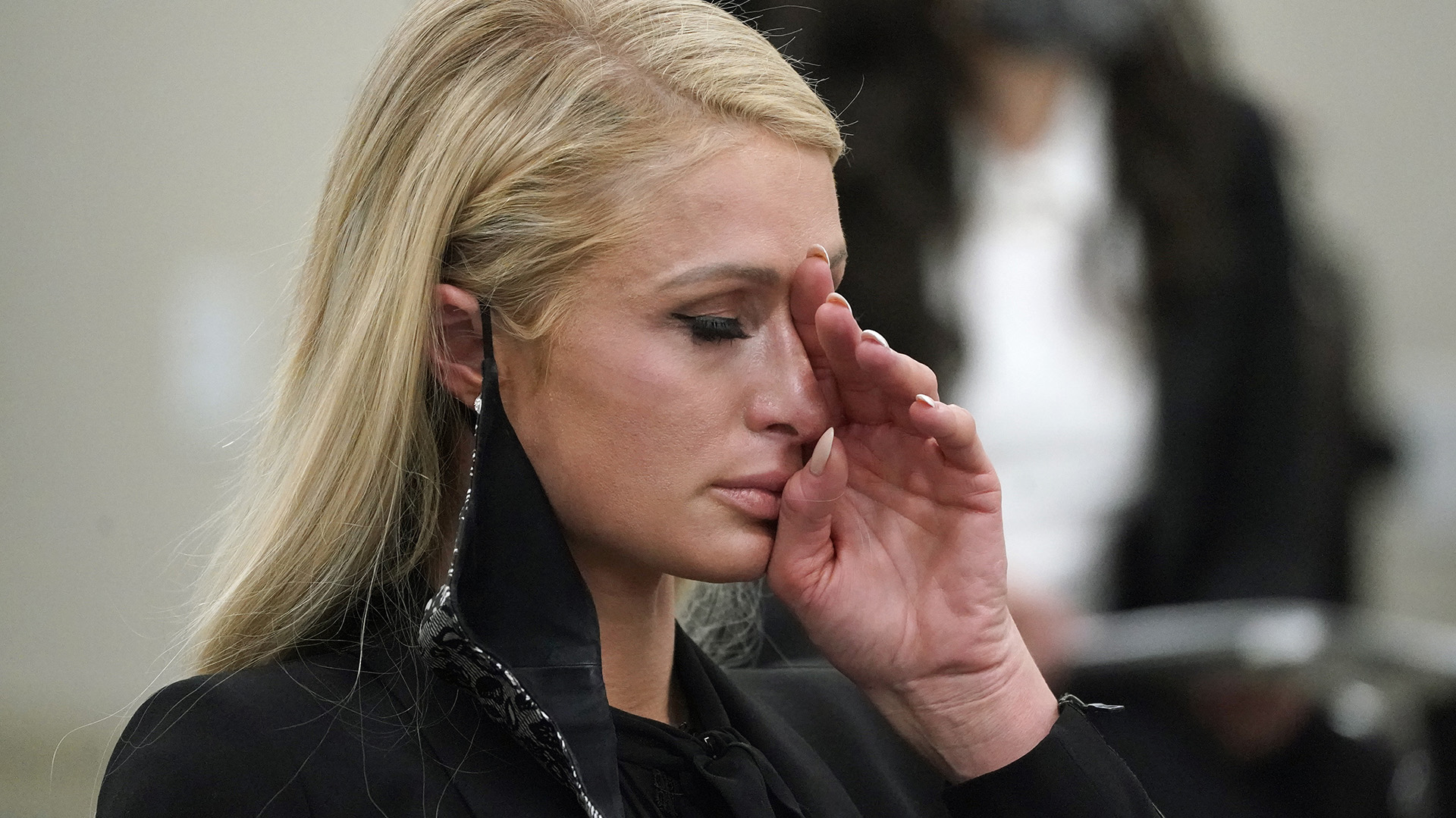 Paris Hilton seca las lágrimas de su rostro mientras daba testimonio frente a la legislatura de Utah el 8 de febrero de 2021 (AP)