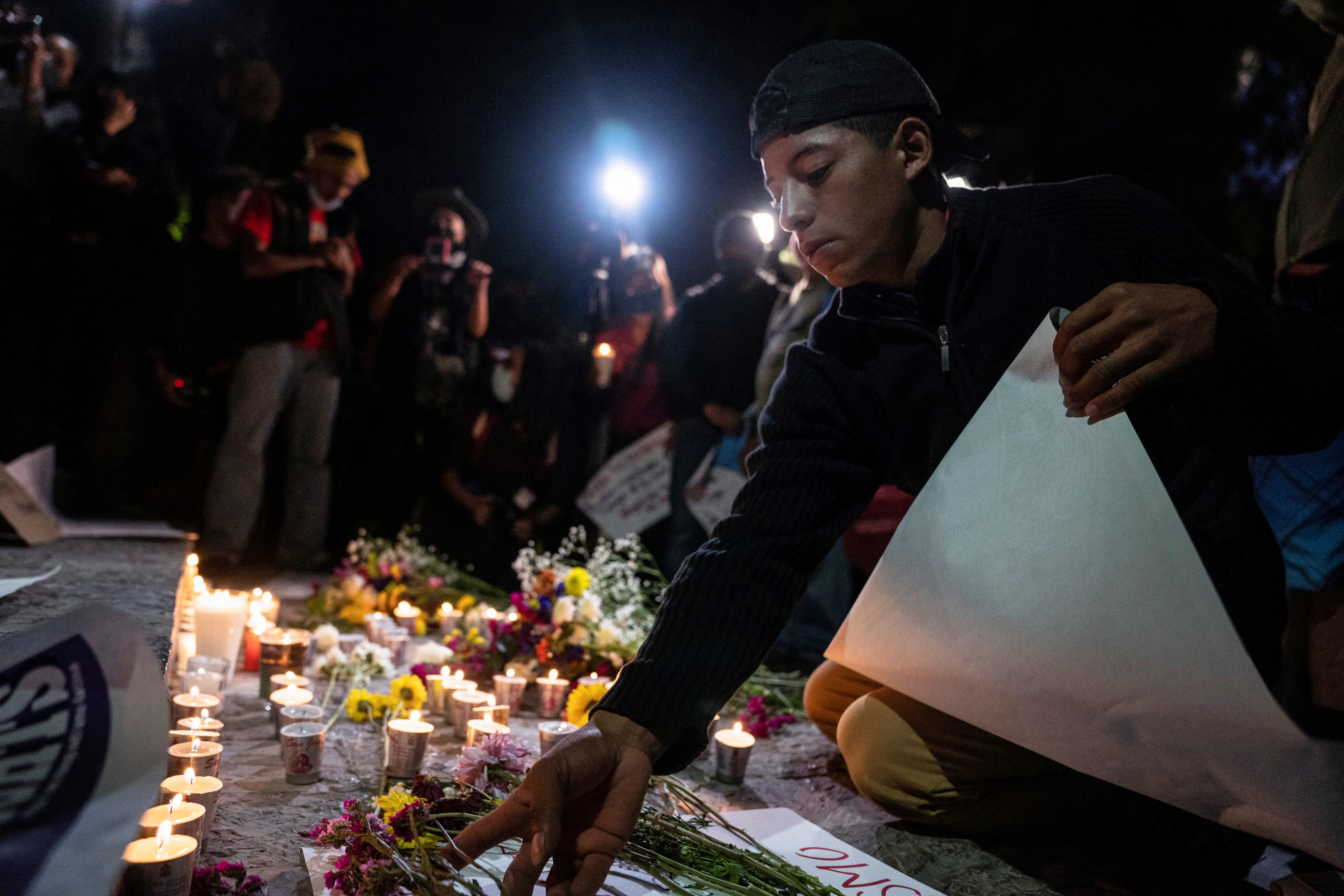 Un migrante deposita flores durante una protesta frente a las oficinas del Instituto Nacional de Migración (INM), bajo el lema "La migración no es un delito" (Foto: Reuters)