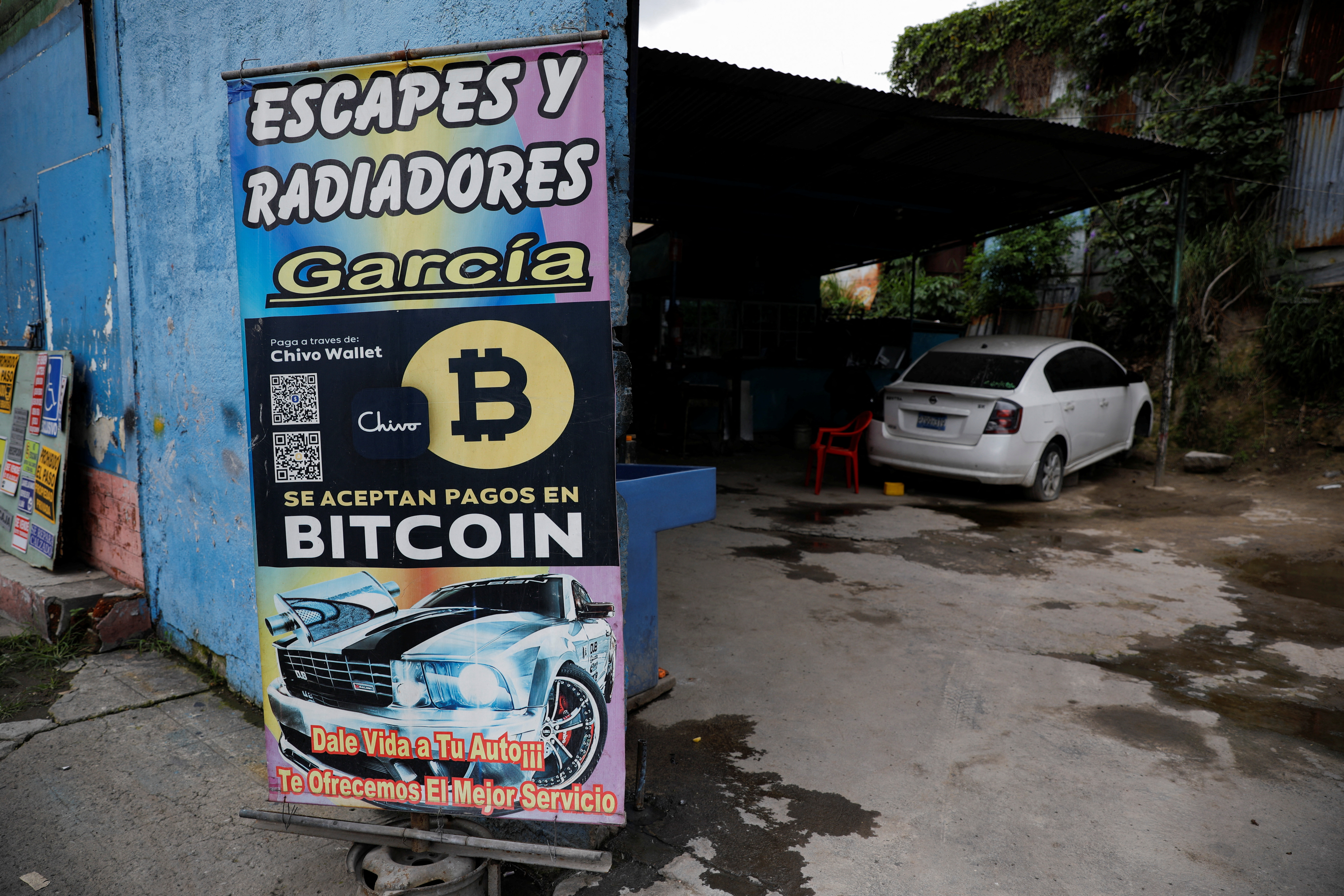 Un cartel de Bitcoin se muestra fuera de un taller automotriz donde se acepta la criptomoneda como método de pago en San Salvador, El Salvador, 13 de julio de 2022. REUTERS/José cabezas
