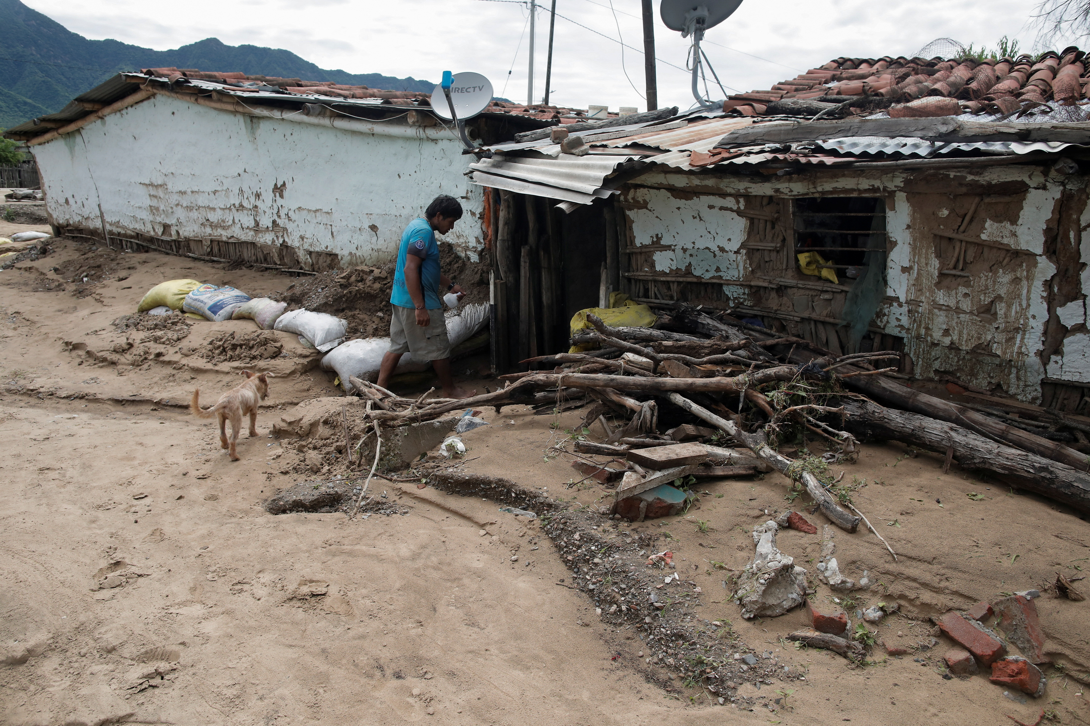 A man enters his house damaged by rains and floods caused by the direct influence of Cyclone Yaku, in Piura, Peru March 11, 2023. REUTERS/Sebastian Castaneda