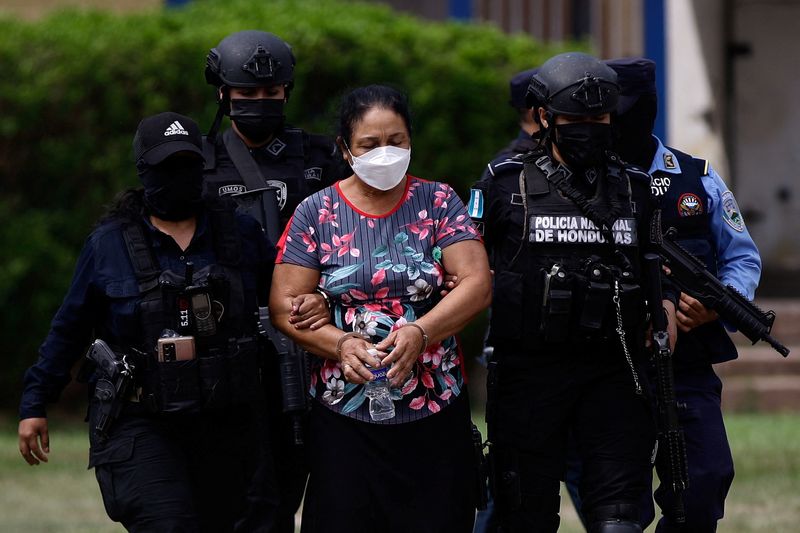 Oficiales de policía escoltan Herlinda Bobadilla luego de una solicitud de extradición para ella y sus hijos por parte de Estados Unidos, en Tegucigalpa, Honduras. 15 de mayo de 2022. REUTERS/Stringer 