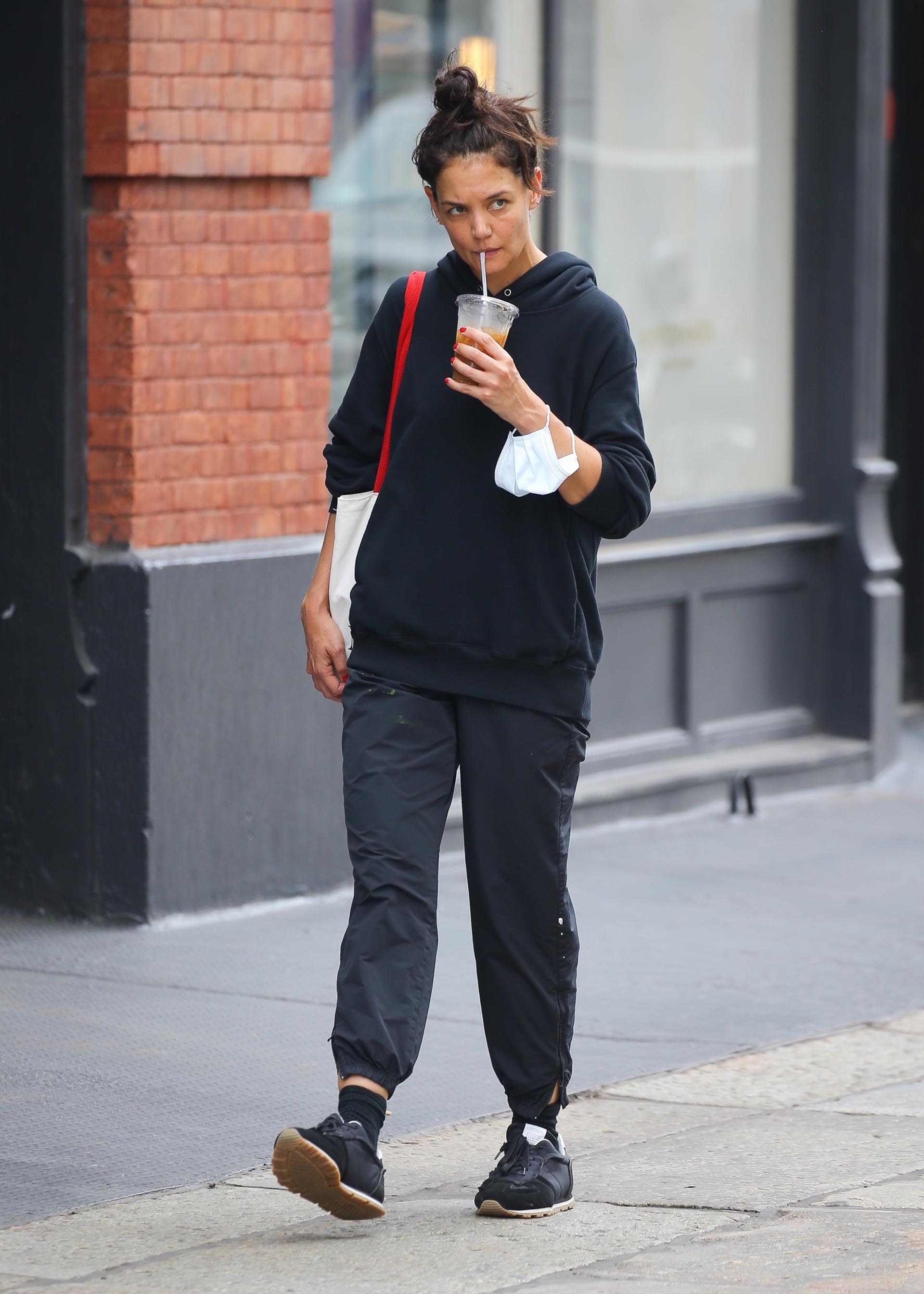 Katie Holmes fue fotografiada mientras daba un paseo por las calles de Nueva York. Compró bebida para llevar y siguió su camino. Lució un look casual: un conjunto de pantalón y buzo, y una cartera blanca con tiras rojas (Fotos: The Grosby Group)
