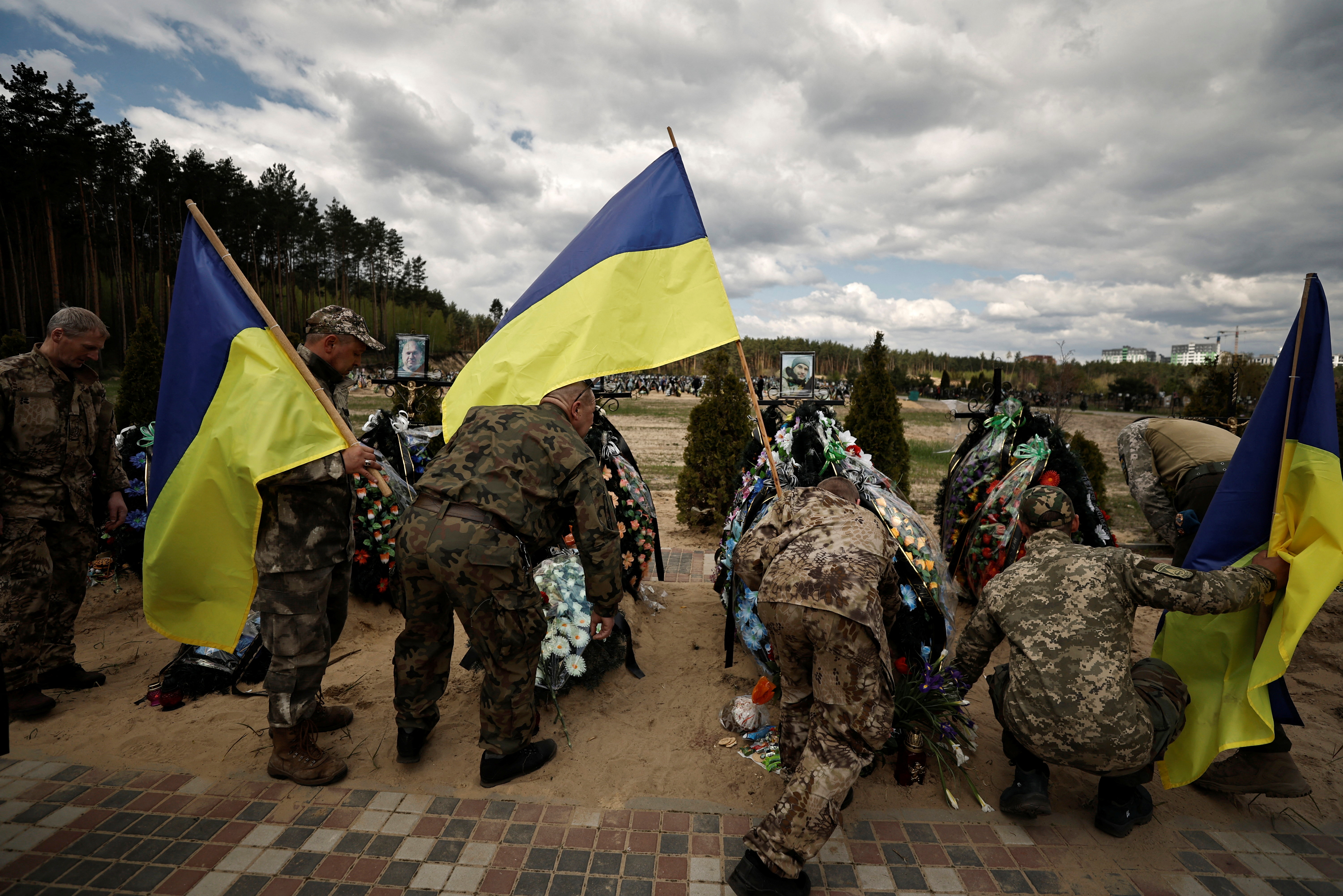 Los miembros de las Fuerzas de Defensa Territorial de Ucrania honran a los soldados caídos durante el fin de semana conmemorativo de la muerte que marca una semana después de la Pascua ortodoxa, el 1 de mayo (REUTERS/Zohra Bensemra)