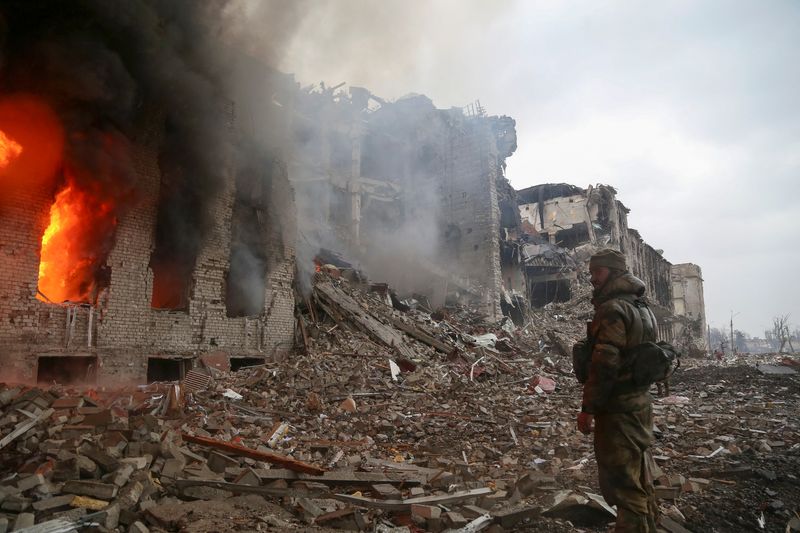 Un miembro del servicio de las tropas prorrusas se encuentra frente al edificio administrativo destruido de la planta siderúrgica de Azovstal en Mariupol, Ucrania, 21 de abril de 2022. REUTERS/Chingis Kondarov