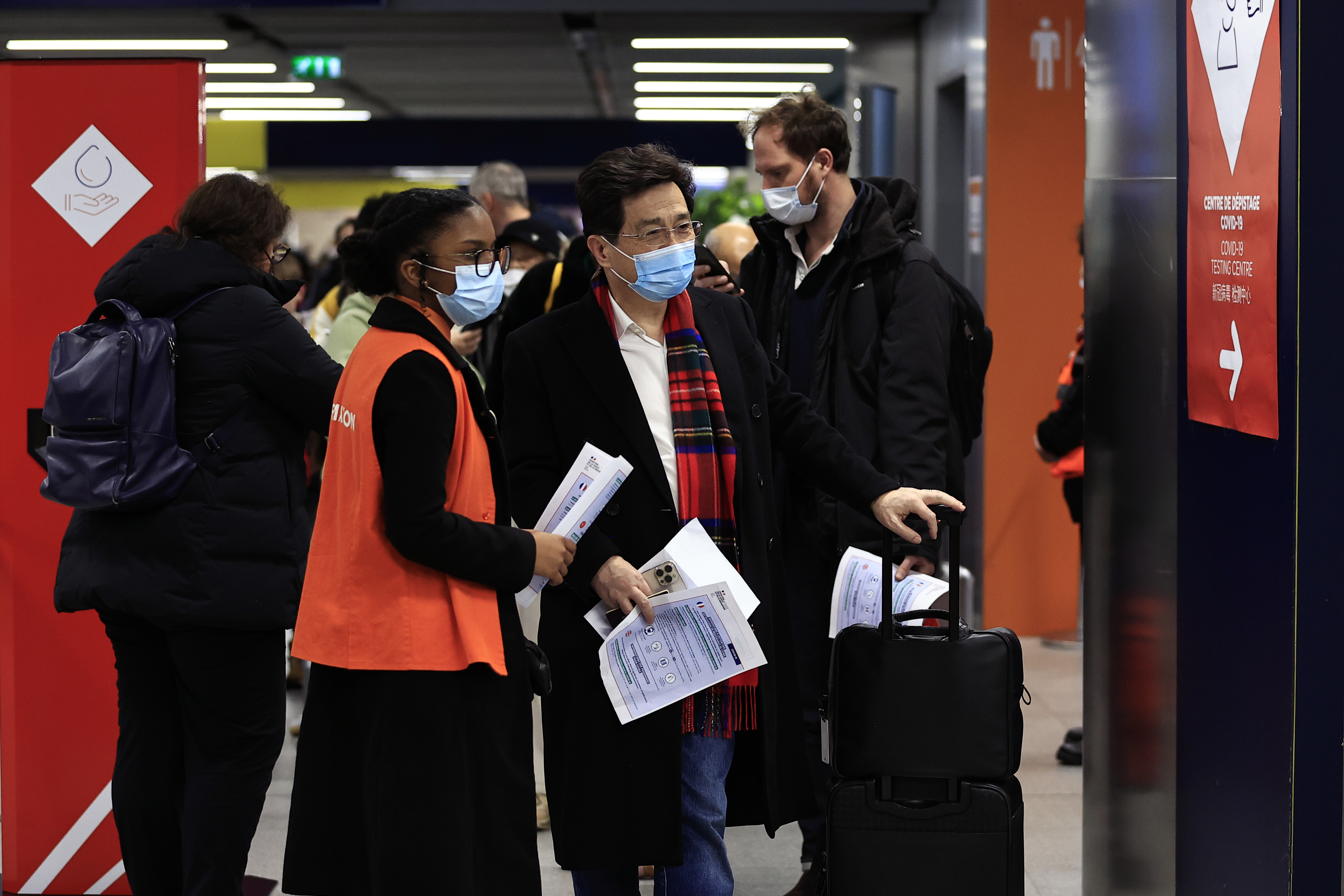 Pasajeros procedentes de China aguardan frente a una zona de pruebas de COVID-19 en el aeropuerto Roissy Charles de Gaulle, al norte de París, el domingo 1 de enero de 2023. (AP Foto/Aurelien Morissard)