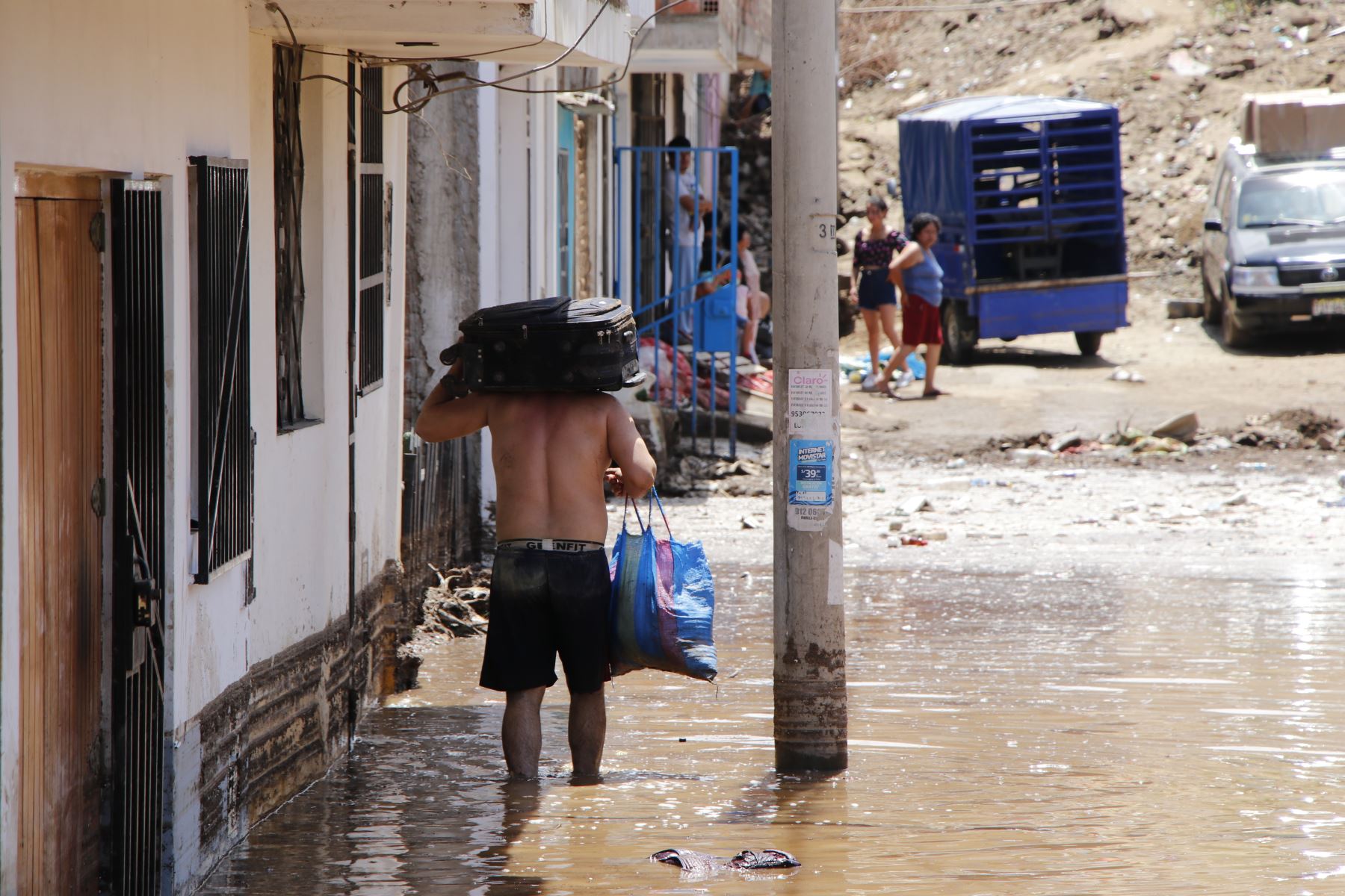 Un hombre rescata sus pocas pertenencias tras el paso del ciclón Yaku. 