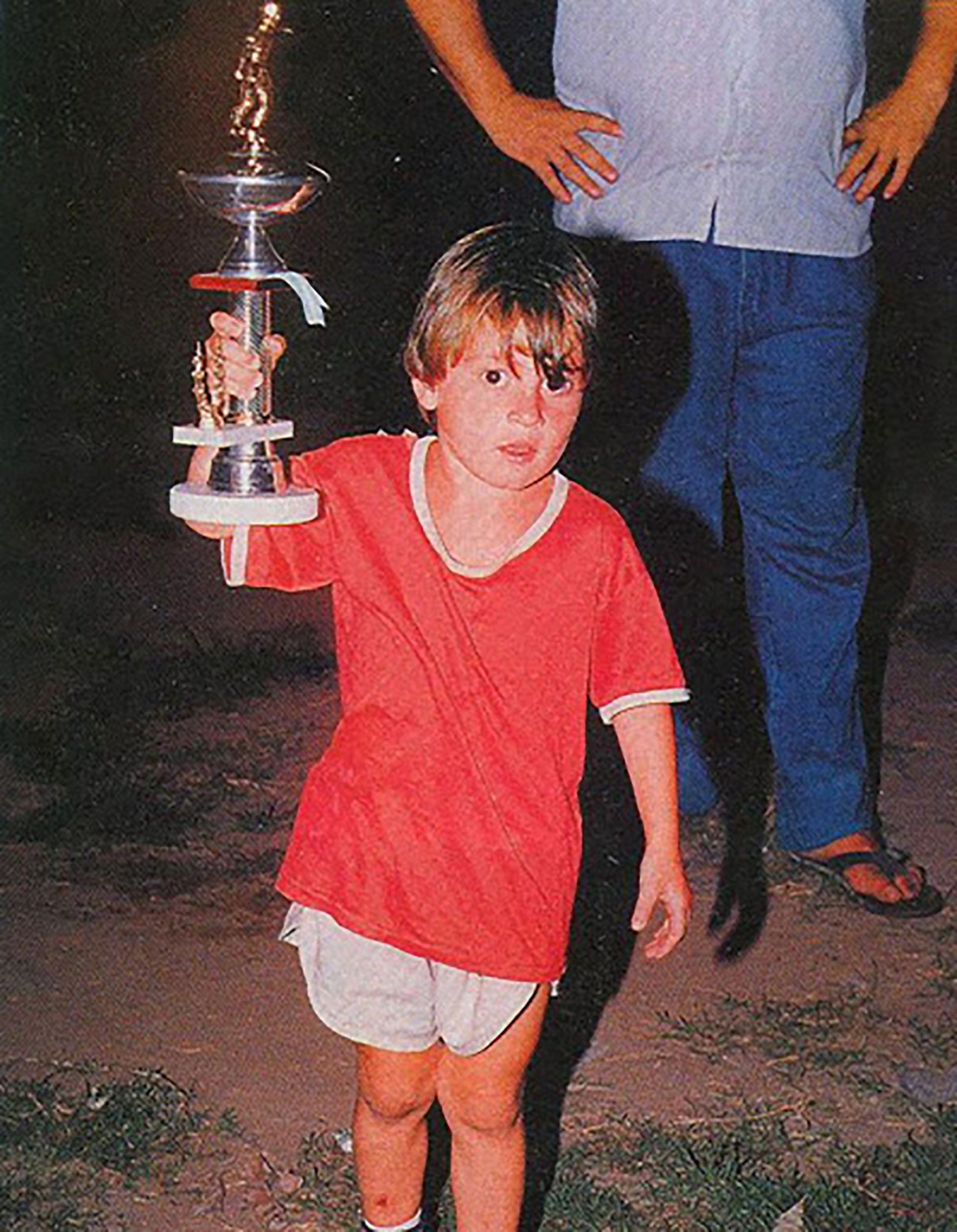 Lionel Messi, de niño, levantando su primer trofeo en Grandoli, el club rosarino donde dio sus primeros pasos en el fútbol