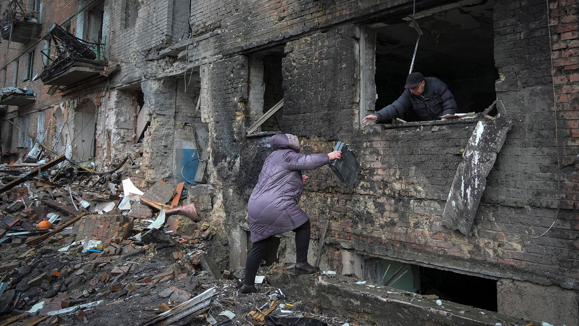 Foto de archivo: una mujer recoge sus pertenencias en una casa dañada después de un bombardeo ruso en la ciudad de Vyshgorod (AP/Efrem Lukatsky)