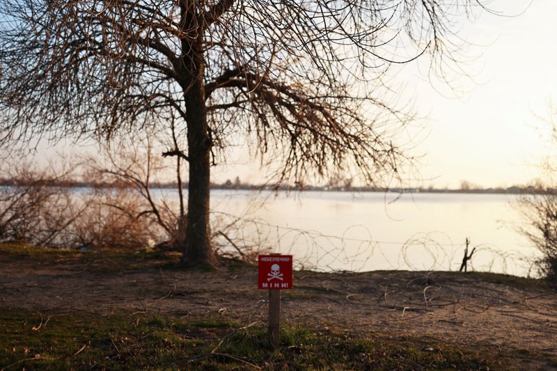 Una señal de peligro de minas frente al río Dnipro, en medio de la invasión rusa de Ucrania, en Kherson, Ucrania. REUTERS/Nacho Doce