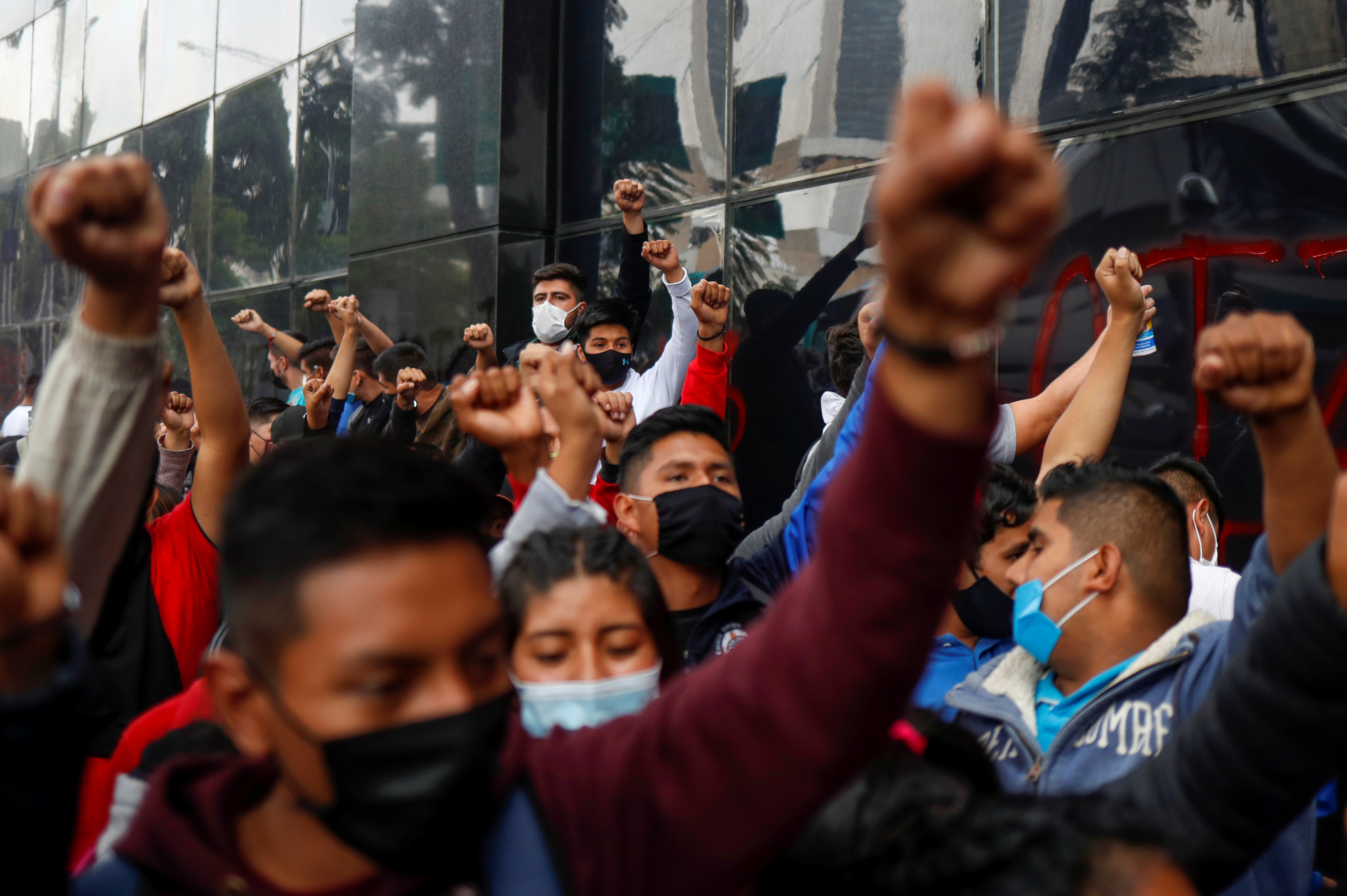 Estudiantes de la Escuela Normal Rural de Ayotzinapa levantan los puños durante una protesta frente a la Fiscalía General antes del sexto aniversario de la desaparición de 43 estudiantes, en la Ciudad de México, México, 25 de septiembre de 2020.