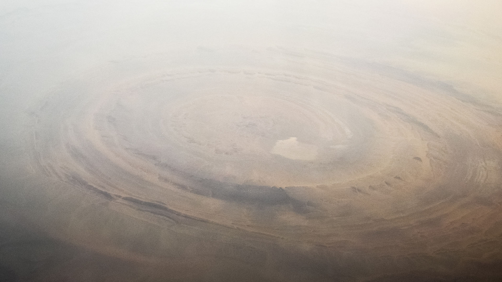 Sahara desert, Mauritania : Aerial view of the Richat Structure, also called Guelb er Richât, the "Eye of Africa" or "Eye of the Sahara" is a deeply eroded, slightly elliptical geologic dome with a diameter of 40 kilometres (25 mi) in the Sahara's Adrar Plateau, near Ouadane, west central Mauritania.