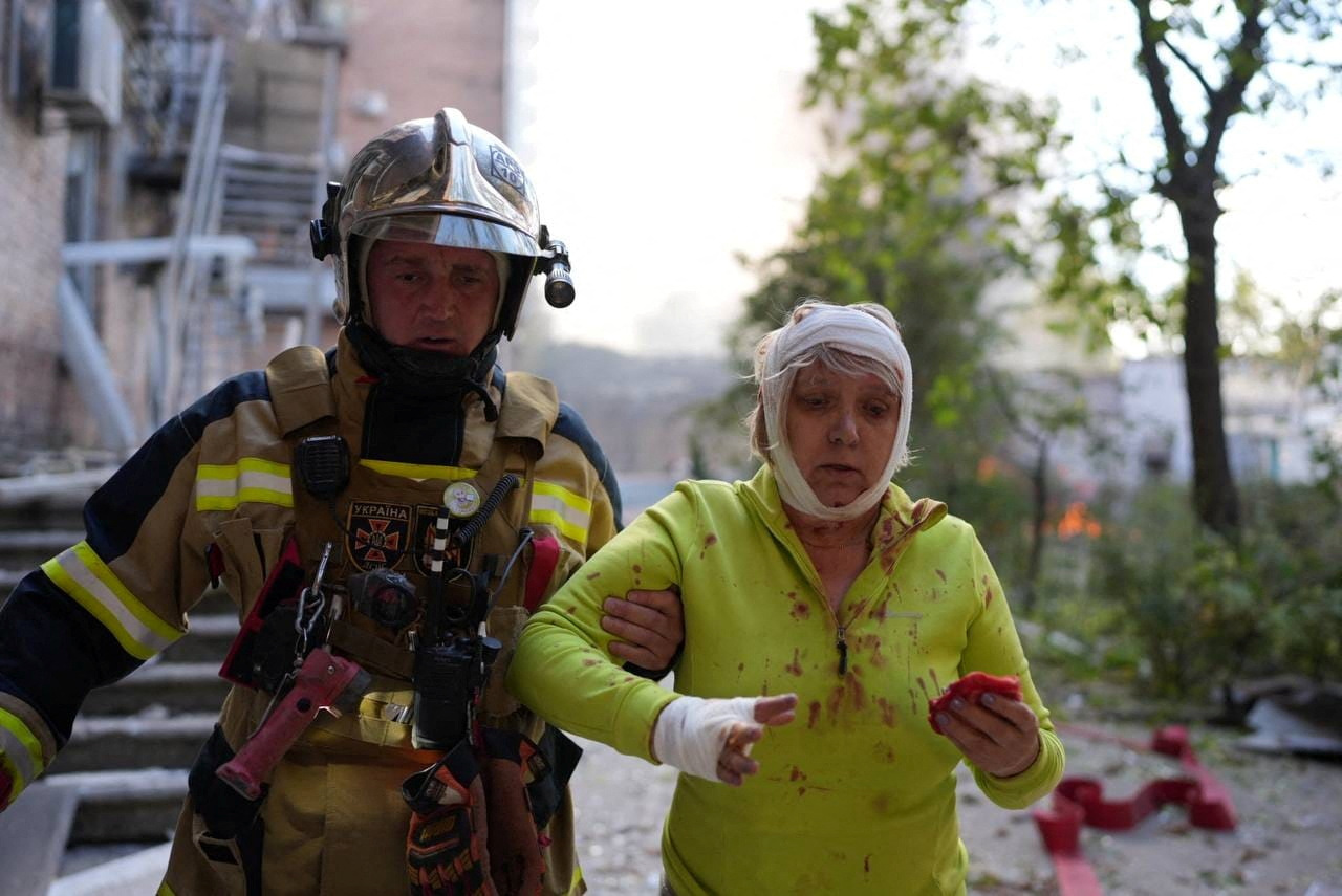 Una mujer herida atendida por los rescatistas tras el bombardeo (REUTERS)