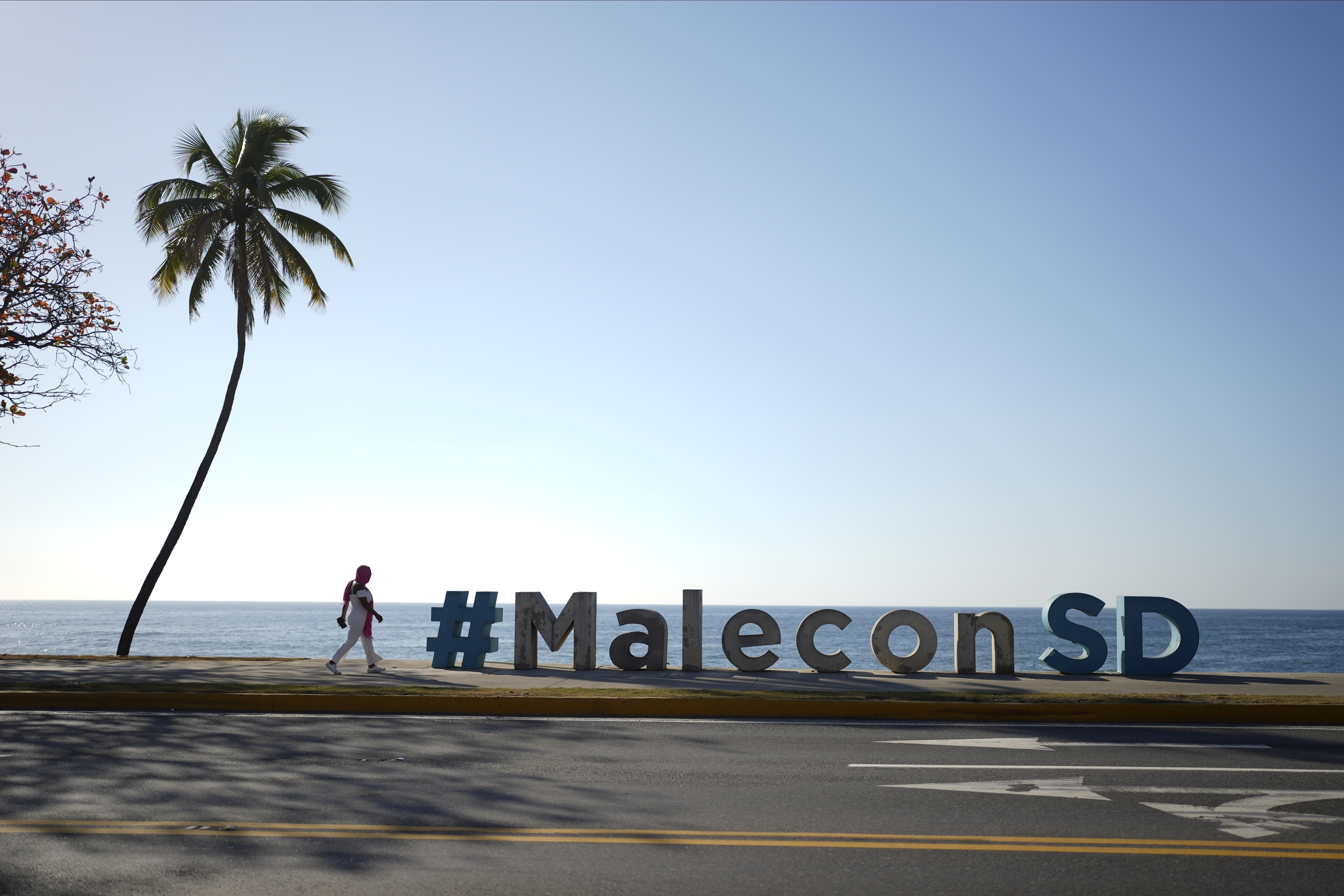 Una persona camina a lo largo del malecón en Santo Domingo, República Dominicana, el viernes 24 de marzo de 2023, mientras la nación caribeña da la bienvenida a los invitados a la 28ª Cumbre Iberoamericana. (Foto AP/Ariana Cubillos)