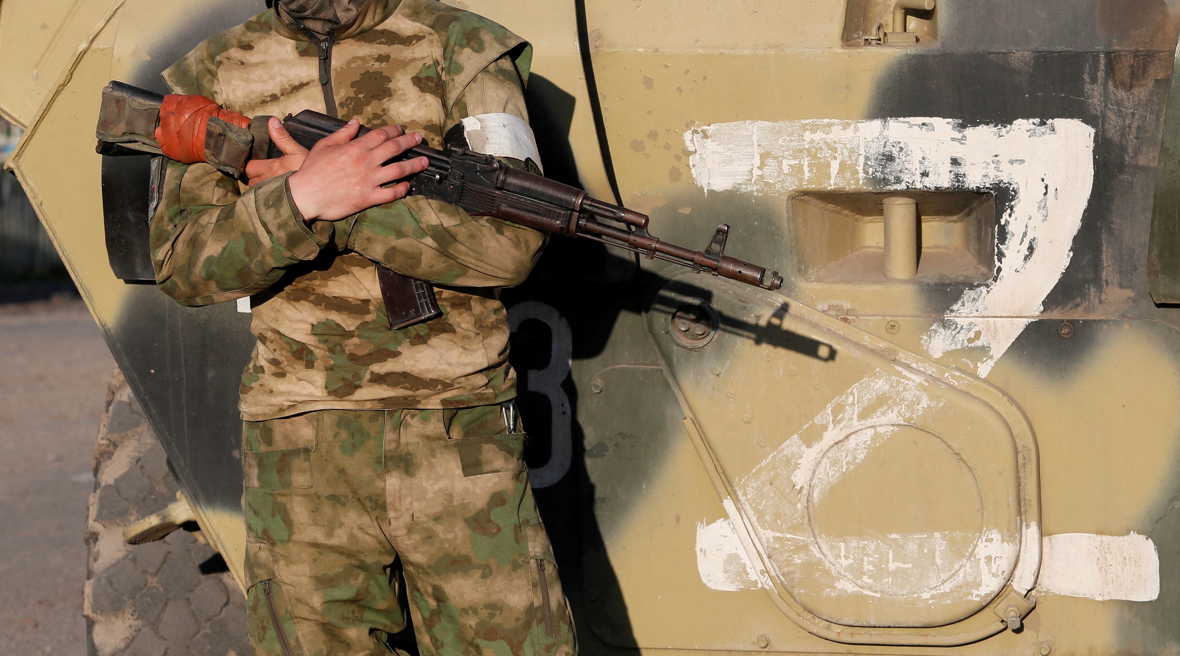 Un miembro de servicio de las tropas prorrusas monta guardia junto a un vehículo de combate, con el símbolo "Z" visto en su lateral en Mariupol (REUTERS/Alexander Ermochenko)