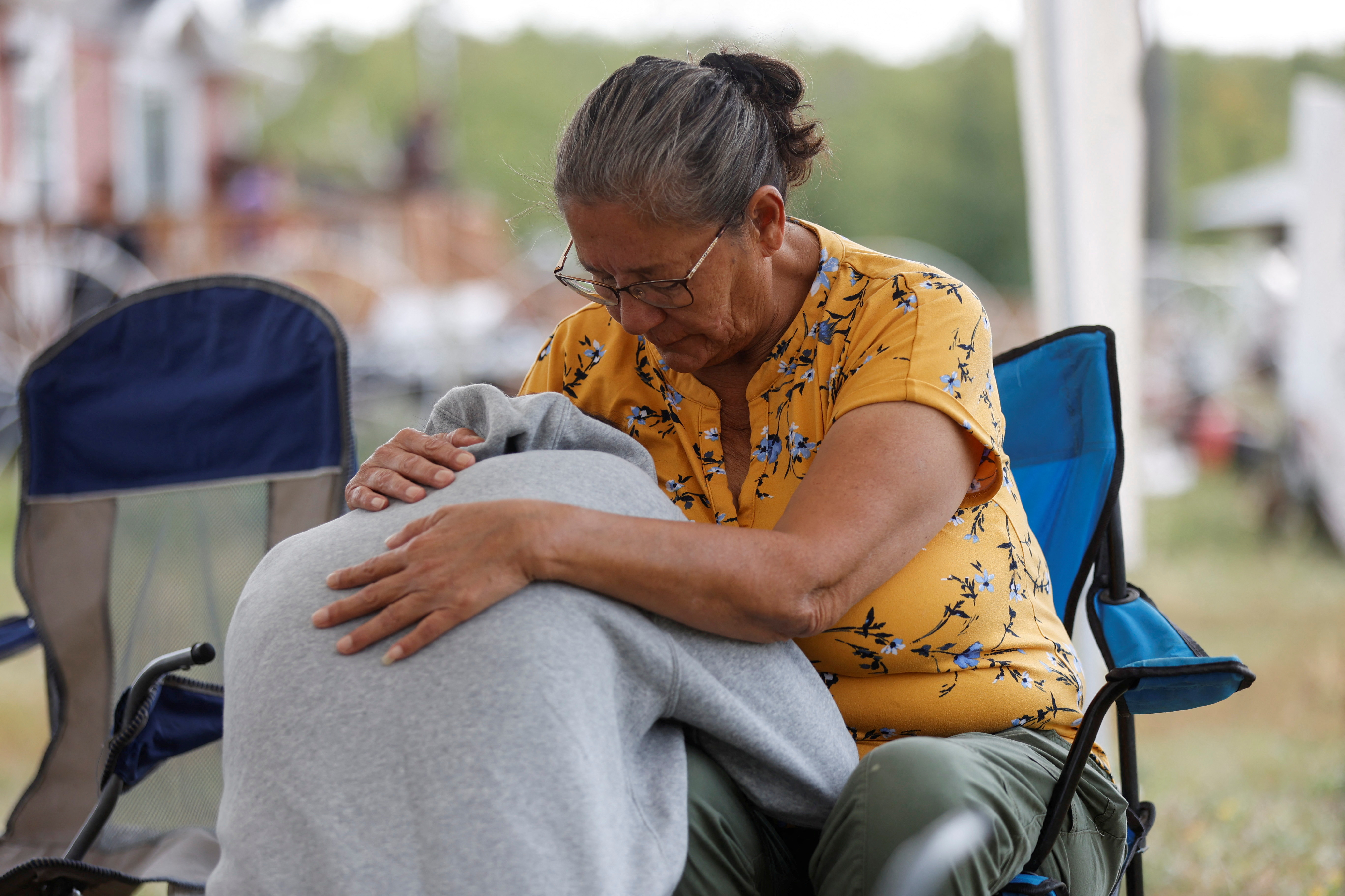 Annie Sanderson comforts her granddaughter, Gloria Lydia Burns, 62, who was killed in the nearby town of Weldon, Saskatchewan, Canada, after James Smith stabbed 10 people in the Cree Nation.  September 5, 2022 (REUTERS/David Stobbe)