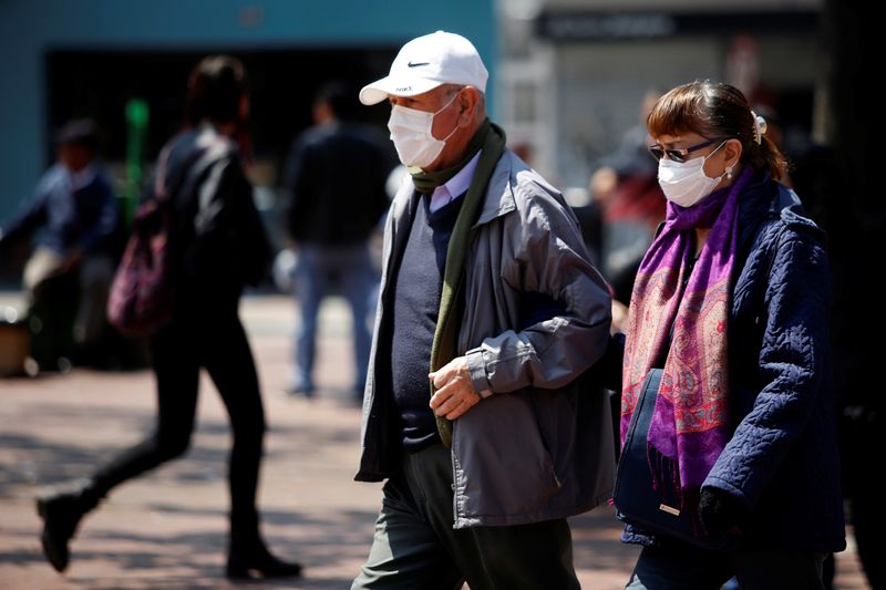 Personas adultas caminan usando tapabocas como medida previentiva para evitar el contagio del coronavirus en una calle de Bogotá, Colombia, 17 de marzo, 2020. REUTERS/Leonardo Muñoz. NO VENTA NO ARCHIVO