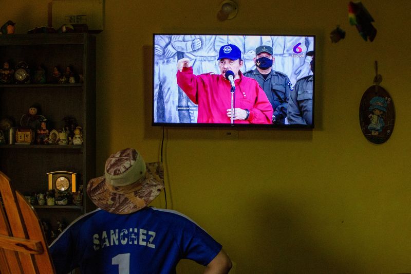 Una persona escucha un discurso de Daniel Ortega transmitido por televisión (REUTERS/Maynor Valenzuela/Archivo)