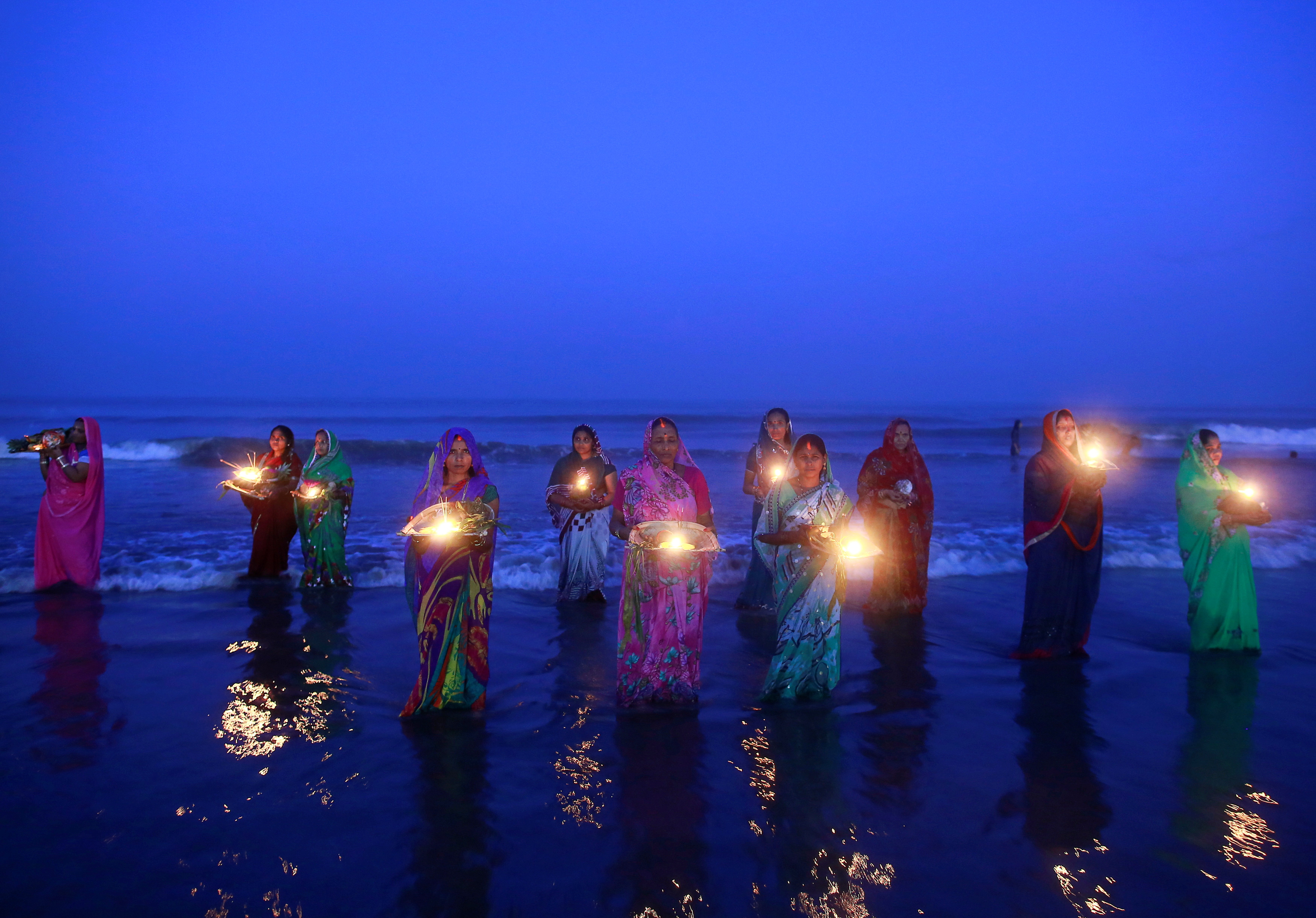 Devotos hindúes rezan de pie en las aguas del Mar Arábigo mientras adoran al dios del Sol Surya durante el festival religioso hindú "Chatt Puja" en Mumbai 30 de octubre de 2014.