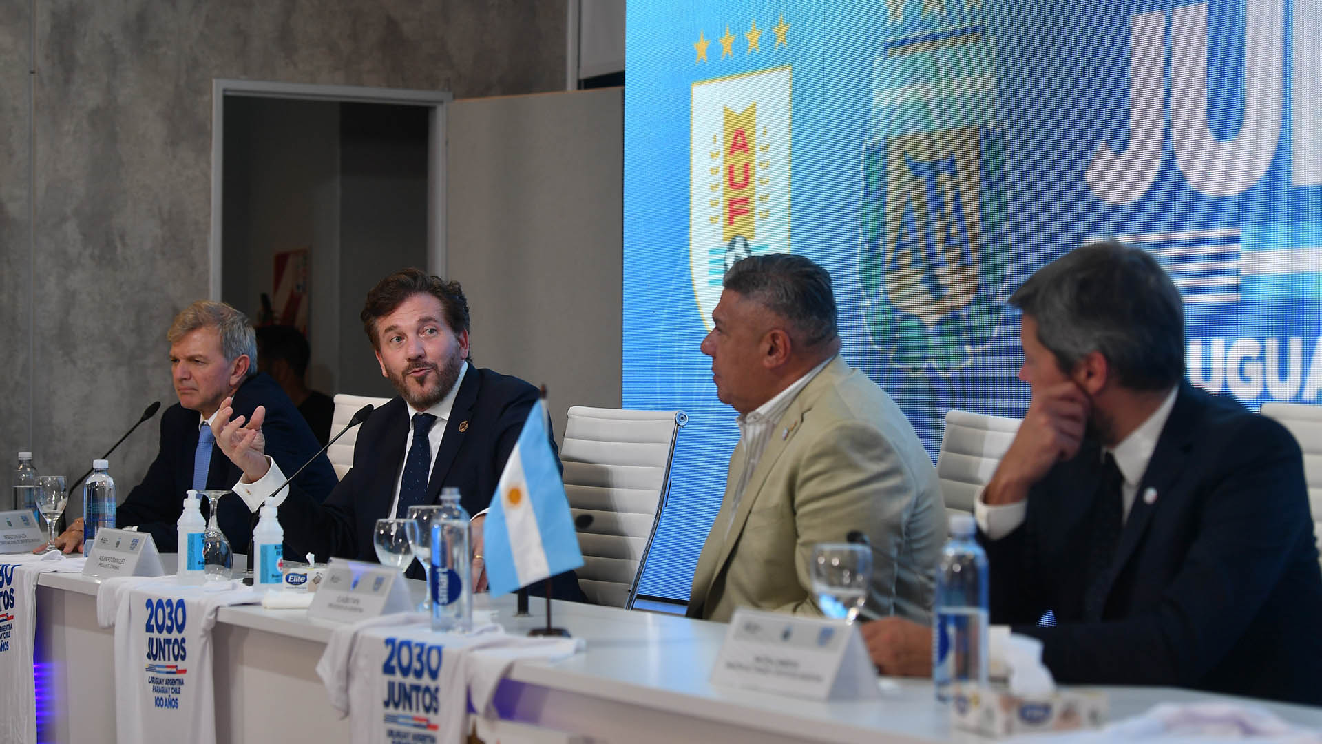 Matías Lammens está acompañado del presidente de la AFA, Claudio Tapia, el mandamás de Conmebol, Alejandro Domínguez, y el Secretario Nacional del Deporte de Uruguay, Sebastián Bauzá.